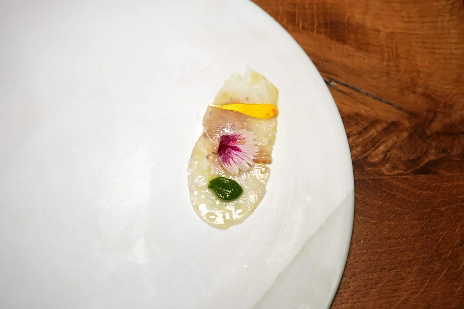 Poisson de nos côtes, levure de bière torréfiée เริ่มต้นด้วย Sea Bass หรือปลากระพงแห่งท้องทะเล Mediterranean แล่มาบาง ๆ จับคู่กับองค์ประกอบของยีสต์ ด้านบนท็อปด้วย Tuna Vinegar ก่อนจะตกแต่งด้วยดอกไม้รับประทานได้ช่วยเพิ่มความสวยงามให้กับชิ้นปลานั่นเอง (17/20)