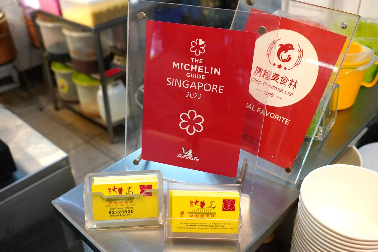 ในส่วนของคุณลูกชายคนเล็กอย่างคุณ Tang Chai Chye นั้นได้แยกตัวออกมาเปิดร้านใหม่ใน Bestway Building บนถนน Prince Edward โดยใช้ชื่อว่า High Street Tai Wah Pork Noodle ซึ่งปัจจุบันปิดทำการไปแล้วก่อนที่ลูกชายของเขาอย่างคุณ Gerald Tang (หรืออีกนัยหนึ่งก็คือหลานชายของคุณ Tang Joon Teo เจ้าของร้านรุ่นแรก) จะเปิดแบรนด์ใหม่เป็นของตัวเองในปี 2003 ภายใต้ชื่อ Tai Wah Pork Noodle ณ ศูนย์อาหาร Hong Lim Food Centre โดยอาศัยสูตรจากคุณพ่อจนสามารถคว้ารางวัล 😋 Bib Gourmand ไปครองได้ตั้งแต่ปี 2018 และขยับขยายสาขาออกไปอีกหลายแห่ง หลังจากที่ได้เล่าถึงลูกชายคนรองและคนเล็กไปแล้วเราขอวกกลับมาเล่าเรื่องราวของลูกชายคนโตอย่างคุณ Tang Chye Hong กันบ้างโดยตัวเขานั้นได้รับคำแนะนำจากคุณพ่อให้เปิดร้านเป็นของตัวเองใน Coffeeshop บนถนน Cecil Street แต่ตัวร้านมีอันต้องปิดทำการลงในปี 1978 ก่อนจะที่ตัวเขาตัดสินใจกลับไปช่วยงานที่ร้านสาขาต้นตำรับซึ่งบริหารงานโดยน้องชายคนกลางอย่างที่กล่าวไปข้างต้น ต่อมาในช่วงปี 1980 คุณ Tang Chye Hong มีความคิดว่าตัวเขานั้นไม่เหมาะกับการทำธุรกิจจึงเปลี่ยนอาชีพมาขับรถแท็กซี่ก่อนจะกลับไปช่วยน้องชายคนกลางอีกครั้งในการย้ายร้านมายังตำแหน่งใหม่คือ Marina Square ในช่วงปี 1990 โดยยังคงทำงานขับรถแท็กซี่ในช่วงกลางวัน อย่างไรก็ตามลูกชายของเขานามว่า Arthur Tung Yang Wee ได้เปิดร้านเป็นของตัวเองอีกครั้งโดยใช้ชื่อว่า Lau Dai Hua Pork Noodle และมีตำแหน่งตั้งอยู่ในศูนย์อาหาร Food Republic ของห้างสรรพสินค้า VivoCity จุดแตกหักของครอบครัวเกิดขึ้นในปี 2008 เมื่อคุณ Arthur Tung Yang Wee ตัดสินใจลงโฆษณาร้านในหนังสือพิมพ์จีน Lianhe Zaobao ถอดความได้ว่าร้านอาหารของเขาจาก Hill Street (“formerly from Hill Street”) ได้ย้ายไปยัง VivoCity (“Had moved to VivoCity”) เป็นเหตุให้เจ้าของร้านต้นตำรับอย่างคุณ Tang Chey Seng ซึ่งมีศักดิ์เป็นคุณอาของคุณ Arthur Tung Yang Wee ตัดสินใจฟ้องร้องหลานชายในทันทีโดยกล่าวอ้างว่าคำโฆษณานี้ก่อให้เกิดความเข้าใจผิดเป็นเหตุให้ยอดขายของร้านลดลงไปกว่า 20 % ทั้งนี้ตัวเขาเองก็ไม่ได้ยินยอมให้นำชื่อ Da Hua ซึ่งเป็นคำ Hanyu Pinyin ของคำว่า Tai Hwa ไปใช้อีกด้วย ในท้ายที่สุดแล้วถึงคุณ Tang Chey Seng จะเป็นฝ่ายแพ้คดีแต่ตัวเขาก็ได้รับเงินชดเชยกลับมาพอสมควรเช่นกัน