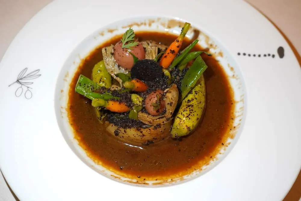 Légumes des jardins de Provence à la truffe noire (105 €) Provence garden vegetables cooked with black truffle เมนู Classic of The House ที่สามารถบ่งบอกอัตลักษณ์และตัวตนของเชฟ Alain Ducasse มากที่สุดคือผักท้องถิ่นคุณภาพสูงซึ่งเป็นวัตถุดิบระดับโลกของแคว้น Provence เช่นถั่ว แครอท เยรูซาเล็มอาร์ติโชค มะเขือเทศ และผักอื่น ๆ อีกหลายชนิดคลุกเคล้ากับซอสที่ได้จากการผสมผสาน Black Truffle น้ำมันมะกอกและ Old Vinegar หรือน้ำส้มสายชูที่ผ่านกระบวนการบ่มมานานเข้าด้วยกัน (19/20)