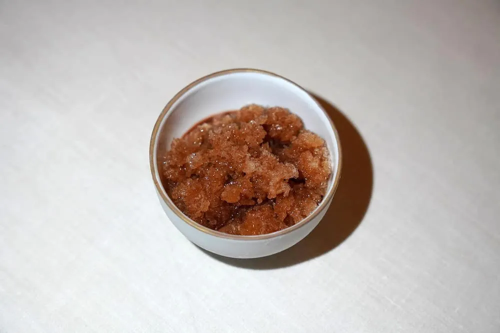 Chocolat Java de notre Manufacture, poivre sauvage, granité grué (40 €) Java chocolate from our Manufacture, wild pepper, cocoa nib granité Java Chocolate เสิร์ฟมาคู่กับ Cacoa Nib Granité ที่ประกอบไปด้วยครีมช็อกโกแลตและน้ำแข็งเนื้อละเอียดทอปอยู่ด้านบน (18/20)