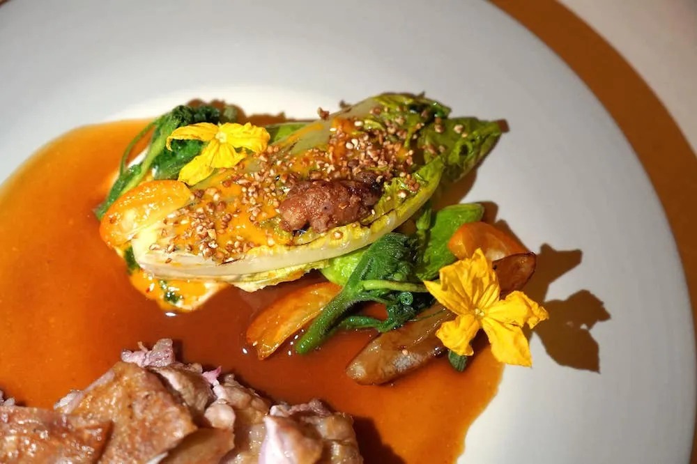 Agneau de lait des Pyrénées à la cheminée, courgette trompette, curry / yaourt (130 €) Lamb from Pyrénées in the fireplace, courgette, curry / yogurt ฝั่งขวามือคือ Green Salad ระกอบไปด้วยผักใบเขียวต่าง ๆ รวมไปถึง Courgette ซึ่งเป็น Zucchini สายพันธุ์ท้องถิ่น ดอกไม้ที่เห็นคือ Cucumber Flower ทุกองค์ประกอบผสมผสานเข้ากับ Curry Condiments ที่ประกอบขึ้นจาก Yogurt, Kumquat และ Lemon Confit (18/20)