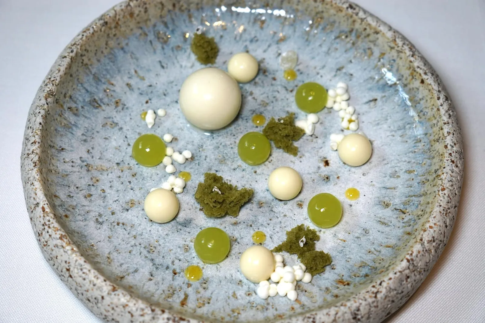 Cardamom spheres, apple and yogurt ของหวานชิ้นแรกเป็นสเฟียร์ทรงกลม เปลือกด้านนอกทำมาจากไวท์ช็อกโกแลต เมื่อกัดจะแตกออกมาเป็นของเหลวทำมาจากกระวานมีกลิ่นหอมเฉพาะตัว ข้าง ๆ กันคือสเฟียร์สีเขียวทำมาจากแอปเปิ้ลเขียวให้รสชาติตัดกันกับกระวาน สปองเค้กสีเขียวทำมาจากถั่วพิสตาชิโอ้ และคาเวียร์ทรงกลมสีขาวทำมาจากโยเกิร์ตช่วยเรียกความสดชื่นได้เป็นอย่างดี รับประทานแต่ละองค์ประกอบสลับกันเพื่อให้มีความแตกต่างทางรสชาติและเนื้อสัมผัส (19/20)