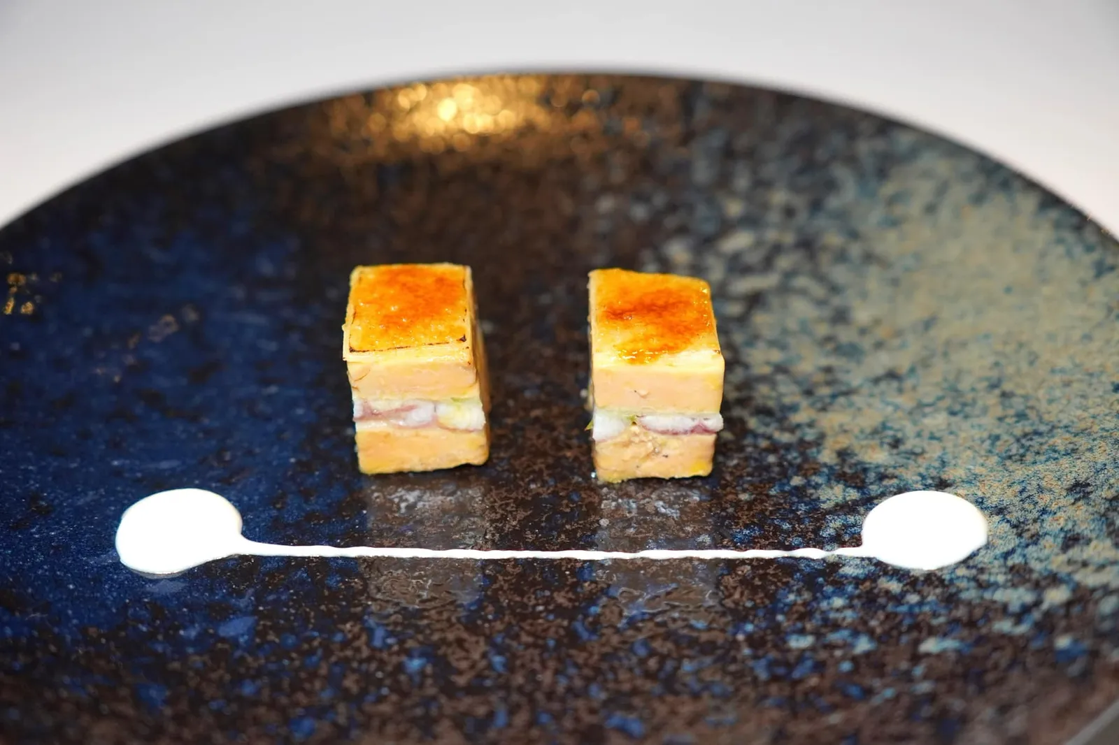 Appetizers สุดยอดเมนู Classic และ Iconic ของเชฟ Martín Berasategui คือ Mille-feuille of smoked eel, foie-gras, spring onions and green apple ได้ถูกยกมาจัดเสิร์ฟที่ห้องอาหาร Lasarte กันด้วย มิลเฟยที่เปลี่ยนจากของหวานมาเป็นของคาวโดยใช้เนื้อปลาไหลทะเลจากทะเล Cantabrian นำมารมควันจับคู่กับฟัวกราส์เรียงซ้อนกันเป็นชั้นโดยให้เนื้อปลาไหลรมควันอยู่ตรงกลางแล้วขนาบชั้นบนล่างด้วยฟัวกราส์ เนื้อปลาไหลมีกลิ่นหอมจากการรมควันในขณะที่ฟัวกราส์ให้เนื้อสัมผัสที่นุ่ม ละมุน ครีมมี่จนเกือบละลายในปาก ด้านบนทอปด้วย Caramelized Granny Smith Apple ชิ้นบาง ๆ ให้รสชาติเปรี้ยวนำและรสหวานจากกระบวนการ Caramelization ทั้งยังช่วยให้มีเลเยอร์กรอบนิด ๆ เป็นการเพิ่มมิติทางเนื้อสัมผัส ครีมสีขาวรอบ ๆ คือ Spring Onion Cream ช่วยเพิ่มความครีมมี่เบา ๆ ให้กับมิลเฟย วิธีรับประทานให้แตะครีมลงบนมิลเฟยแล้วรับประทานทั้งคำแบบ One bite แม้จะถูกคิดค้นมานานกว่า 28 ปี ทั้งยังใช้เทคนิคอันซับซ้อนแต่กลับให้ผลออกมาเป็นเมนูที่ดูเรียบง่าย รสชาติที่ได้ยังคงมีความร่วมสมัย อร่อยชนิดที่หาใครเทียบได้ยากจนถึงปัจจุบัน (20/20)