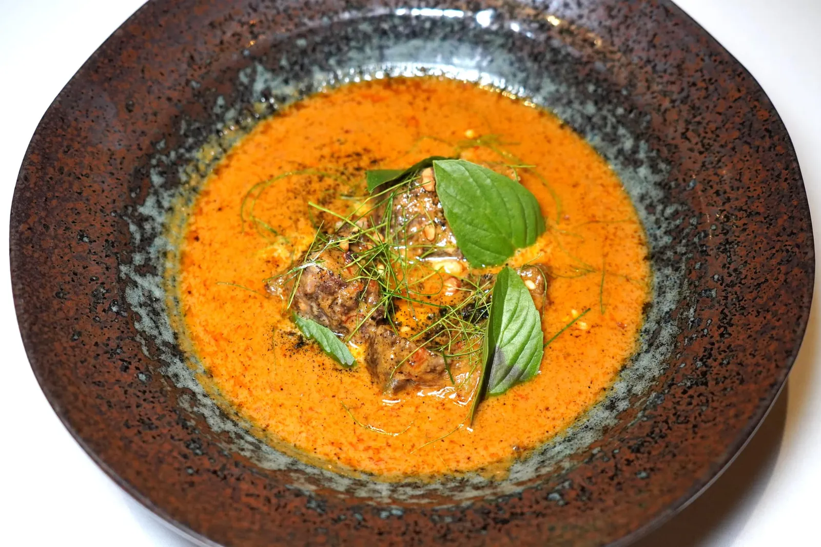 แพนงเนื้อออสเตรเลีย (950++) Panaeng curry of roasted Australian grain feed-beef cheek, toasted peanuts & Thai sweet basil จานที่ดีที่สุดต้องยกให้กับแกงแพนงสูตรโบราณที่ทางร้านทำเอง เชฟเคี่ยวน้ำกะทิในไฟอ่อนจนแตกมันสังเกตได้จากการกลืนเป็นเนื้อเดียวกันไปกับเครื่องแกง ทั้งยังมีระดับความเข้มข้นพอเหมาะ รสชาติออกหวานนำในขณะที่รสเผ็ดจะค่อย ๆ ตามมาทีหลัง เนื้อแก้มวัวออสเตรเลียผ่านการตุ๋นมาจนนุ่ม ด้านล่างมีถั่วลิสงคั่วช่วยเพิ่มกลิ่นหอมและมิติทางเนื้อสัมผัสขณะเคี้ยว ด้านบนโรยด้วยใบมะกรูดและใบโหระพาให้กลิ่นหอมและอโรมาเฉพาะตัว (16/20)