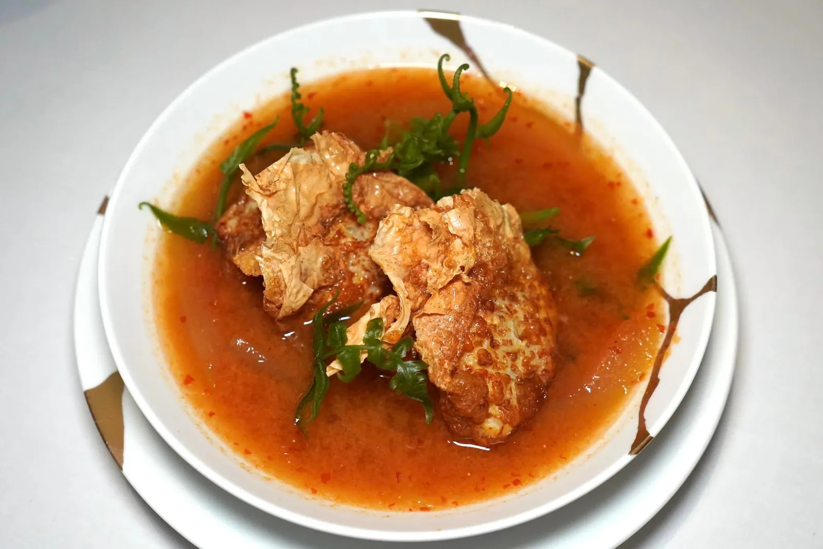 แกงเปลือกแตงโมกับฟองเต้าหู้ห่อปลากับมันแกว (700++) Watermelon rind and fish roe soup with seabass & jicaman dumplings แกงเปลือกแตงโมให้รสชาติอยู่ระหว่างแกงเลียงและต้มยำ มีกลิ่นหอมเฉพาะตัว เปลือกแตงโมมีความนุ่มคล้ายกันกับฟักแต่นุ่มกว่าอยู่เล็กน้อย เชฟเพิ่มความหอมมันโดยการใส่ไข่ปลาลงไปด้วย เ้านบนเป็นฟองเต้าหู้กรอบ ด้านในสอดไส้มันแกวและเนื้อปลากะพงทำให้เกิดมิติเนื้อสัมผัสที่ลงตัว (15/20)
