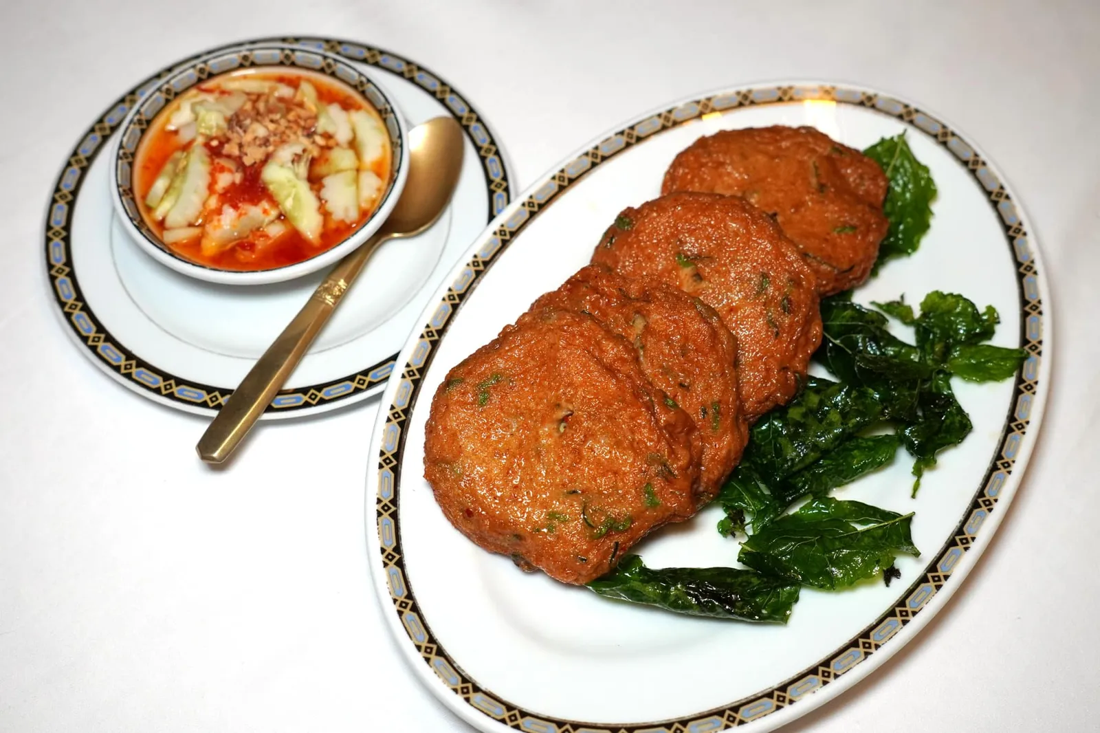 ทอดมันปลากราย (240++) Deep fried spicy fish cakes ทอดมันปลากรายเป็นเมนูที่ได้รับความนิยมมาตั้งแต่สมัยร้านศรแดงเดิม เชฟจิระวุฒิ ทรัพย์คีรี ตัดสินใจคงเมนูนี้เอาไว้อย่างถาวรเพราะเหล่านักชิมในสมัยนั้นต่างเห็นพ้องต้องกันว่ามอดมันปลากรายที่นี่ทำออกมาได้ดีที่สุดในกรุงเทพ ทางร้านใช้เฉพาะเนื้อปลากรายล้วนไม่ผสมแป้งนำไปนวดคลุกเคล้ากับพริกแกงอย่างดี จากนั้นนำลงทอดแบบจานต่อจานจนมีสัมผัสนุ่ม เนียน หนึบ ไม่เหนียว กัดแล้วสามารถสัมผัสได้ถึงกลิ่นเครื่องแกงหอมแตะจมูกเด่นชัด เสิร์ฟมากับน้ำจิ้มรสเด็ดและใบกระเพรากรอบให้กินสลับกัน (15/20)