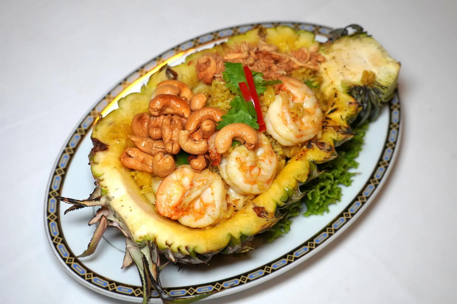 ข้าวอบสับปะรด (290++) Baked pineapple curry rice with shrimps ทางร้านคัดสับปะรดขนาดพอเหมาะจากเมืองจันทบุรีนำผัดกับผงกะหรี่ชั้นดีเมล็ดข้าวสุกได้ระดับ กลิ่นผงกะหรี่หอมพอดีไม่แสดงออกจนเด่นชัดเกินไป ยังมีเนื้อกุ้ง หมึก พริกหวาน และเนื้อสับปะรด ด้านบนทอปด้วยหมูหยอง กุ้ง เมล็ดมะม่วงหิมพานต์ช่วยเพิ่มมิติทางเนื้อสัมผัสเสิร์ฟมาในสับปะรดผ่าครึ่งดูน่ากินมากจริง ๆ (14/20)