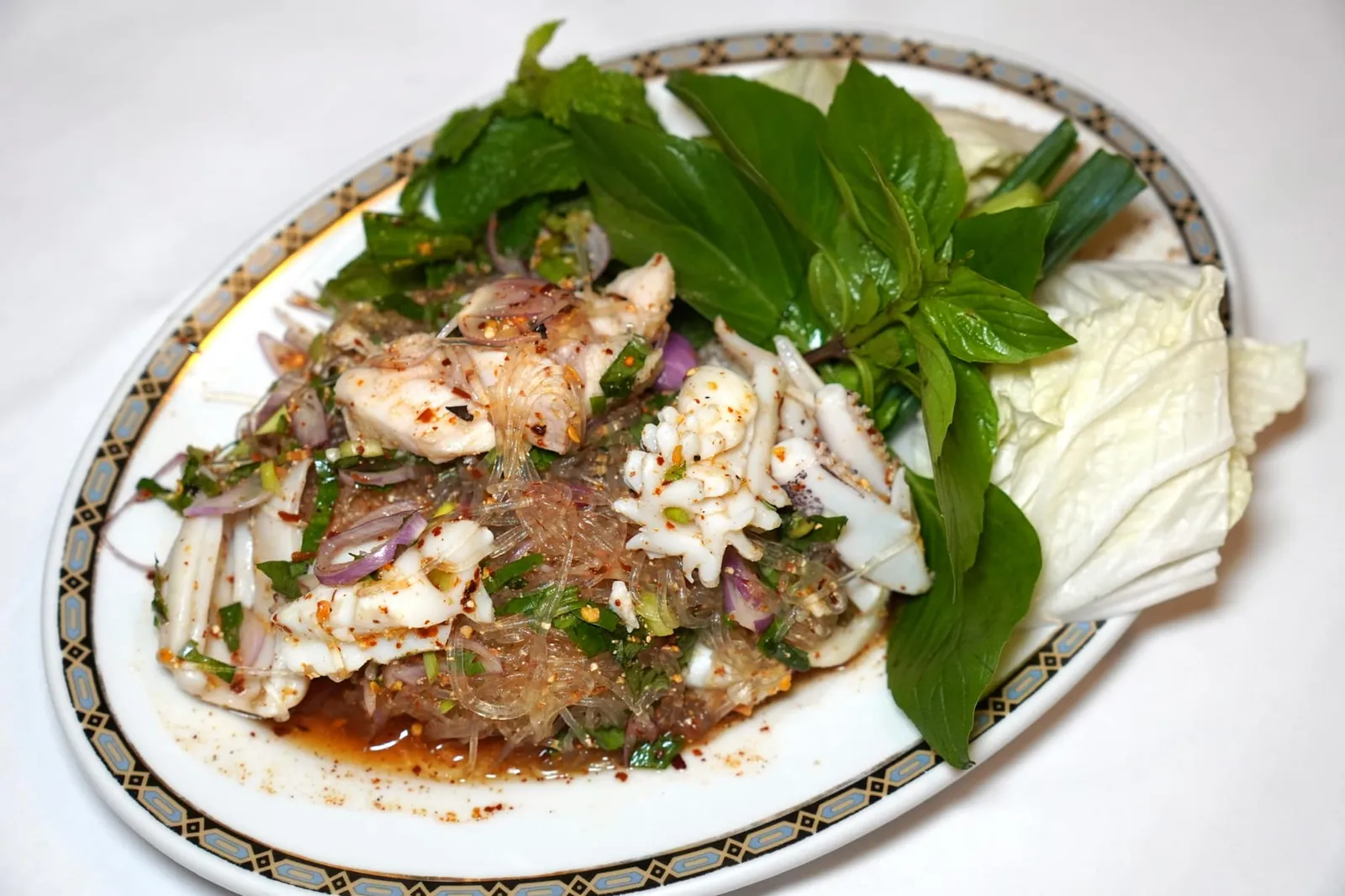 ลาบวุ้นเส้นรวมมิตรทะเล (300++) Spicy seafood salad with grass noodles North-Eastern style เห็นว่าเป็นร้านอาหารไทยภาคกลางสไตล์ชาววังก็อย่าได้ดูถูกรสมือการทำอาหารอีสานของเค้าเลยเชียวเพราะลาบวุ้นเส้นรวมมิตรทะเลจานนี้ใช้หมึกชิ้นโตขนาดเต็มปากเต็มคำที่ผ่านการบั้งและลวกจนสุกพอดี กัดแล้วได้สัมผัสความหนึบแต่ไม่เหนียว ในขณะที่เนื้อปลาแน่น เฟิร์ม แต่ไม่กระด้าง เสิร์ฟมากับวุ้นเส้นและน้ำลาบรสชาติจัดจ้าน เปรี้ยว หวาน เค็ม เผ็ด หอมกลิ่นข้าวคั่วขึ้นจมูก อร่อยจนกลายมาเป็นอีกหนึ่งเมนูโปรดของเราอย่างไร้ข้อกังขา (14/20)