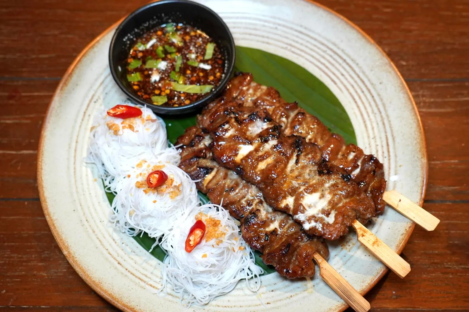 หมูปิ้งกะทิสด (110++) Grilled Coconut Milk Marinated Pork Skewers อีกหนึ่งจานที่ออกมาได้อย่างโดดเด่นคือเนื้อหมูชิ้นโตเสียบไม้ผ่านการทาด้วยกะทิสด จากนั้นย่างจนนุ่มสุกกำลังพอดี ทั้งยังมีความหอมมันจากกะทิตัดกับความจัดจ้านของน้ำจิ้มแจ่วอีสานที่เสิร์ฟมาคู่กัน (13/20)