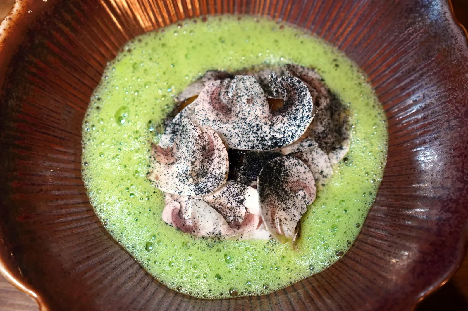 Egg Yolk / Wild Garlic / Morels หนึ่งในจานที่ดีที่สุดในวันนี้ต้องให้กับไข่แดงที่ผ่านการกงฟีในน้ำมันด้วยไฟอ่อน ๆ จนสุกวางอยู่ที่ก้นจานเคียงคู่กับเห็ด Shiitake และ Morels ด้านบนคือ Champignon de Paris แล่มาบาง ๆ คล้ายกับ Carpaccio โรยด้วยผงสีดำทำมาจากกระเทียมดำ เพิ่มมิติทางเนื้อสัมผัสด้วยการใส่ข้าวพองและครูตองกรอบ สุดท้ายคือ Emulsion สีเขียวที่ผสมผสานแกงเขียวหวาน, น้ำกะทิ และกระเทียมป่าเข้าด้วยกัน (15/20)