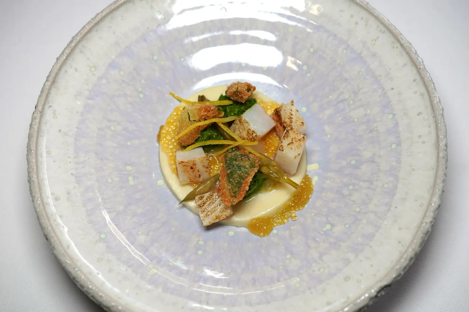Brochet et ail des ours Pike fish and wood garlic Brochet หรือ Pike Fish เป็นปลาน้ำจืดที่พบได้ในแถบนี้ เชฟนำเสนอมาในหลากหลายองค์ประกอบเริ่มจากส่วนเนื้อปลาที่เชฟนำไปหมักกับเลมอน องค์ประกอบสีขาวรอบ ๆ คือ Brochet Quenelle หรือเนื้อปลาที่นำไปผสมกับครีมทำออกมาเป็นเคอร์เนลเนื้อนุ่มละมุน ยังมีไข่ปลา Pike Fish ใส่มารอบ ๆ จากนั้นจับคู่กับ Wild Garlic หรือกระเทียมป่าเสิร์ฟทั้งในรูปแบบ Wild Garlic Emulsion, Wild Garlic Crispy และ Wild Garlic Pesto นั่นเอง (20/20)