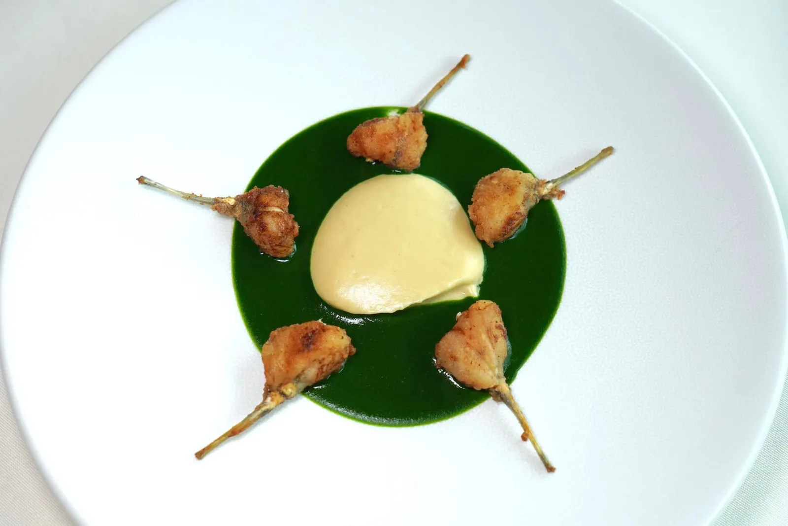 Fresh frog's legs garlic purée and parsley sauce Jambonnettes de grenouilles à la purée d'ail et au jus de persil หรือขากบทอดเสิร์ฟมาคู่กับพูเรกระเทียมและซอสพาสลีย์เป็นหนึ่งใน Bernard Loiseau's classics ที่ได้จากการนำเมนูพื้นบ้านประจำแคว้น Burgundy มาปรับสูตรโดยการลดอัตราส่วนของเนยและเพิ่มปริมาณของกระเทียมลงไป ผลที่ได้คือเนื้อส่วนขากบที่ผ่านการเตรียมมาอย่างดีดูคล้ายแฮมชิ้นเล็ก ๆ (Jambonnettes) เนื้อสัมผัสนุ่มละมุนลิ้นตัดกันกับความกรอบของแป้งที่ห่ออยู่บาง ๆ ด้านนอก ทั้งยังมีกลิ่นหอมกระเทียมเข้าเนื้อติดอยู่ในปากนานยิ่งขึ้นกว่าเดิม สำหรับซอสพาสลีย์นั้นมีกลิ่นเฉพาะตัวเข้ากันดีกับอโรมาของกระเทียมที่ไม่แรงจนเกินไป เชฟ Bernard Loiseau ตั้งใจรังสรรค์เมนูนี้ให้เต็มไปด้วยความเรียบง่าย ไม่ซับซ้อน แต่กลับกลายมาเป็นหนึ่งใน Iconic Dish ที่ดีที่สุดตลอดกาลของห้องอาหาร La Côte d'Or มาจนถึงปัจจุบัน (17/20)