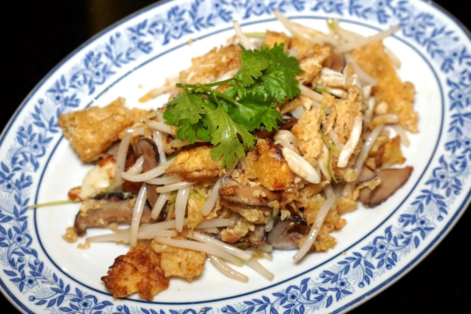 กระเพาะปลาผัดไข่ (220+) Fried Fish Maw with Egg and Bean Sprout จานนี้ทางร้านเลือก ชิ้นกระเพาะปลาคุณภาพดีผัดกับไข่และเนื้อปูในกระทะด้วยไฟสูงจนเกิดกลิ่นหอมเฉพาะ ชิ้นกระเพาะปลาผิวกรอบแต่เนื้อข้างในยังคงนุ่มฉ่ำตัดกันกับความหนึบของเห็ดหอมและความกรอบของถั่วงอกได้อย่างลงตัว (14/20)