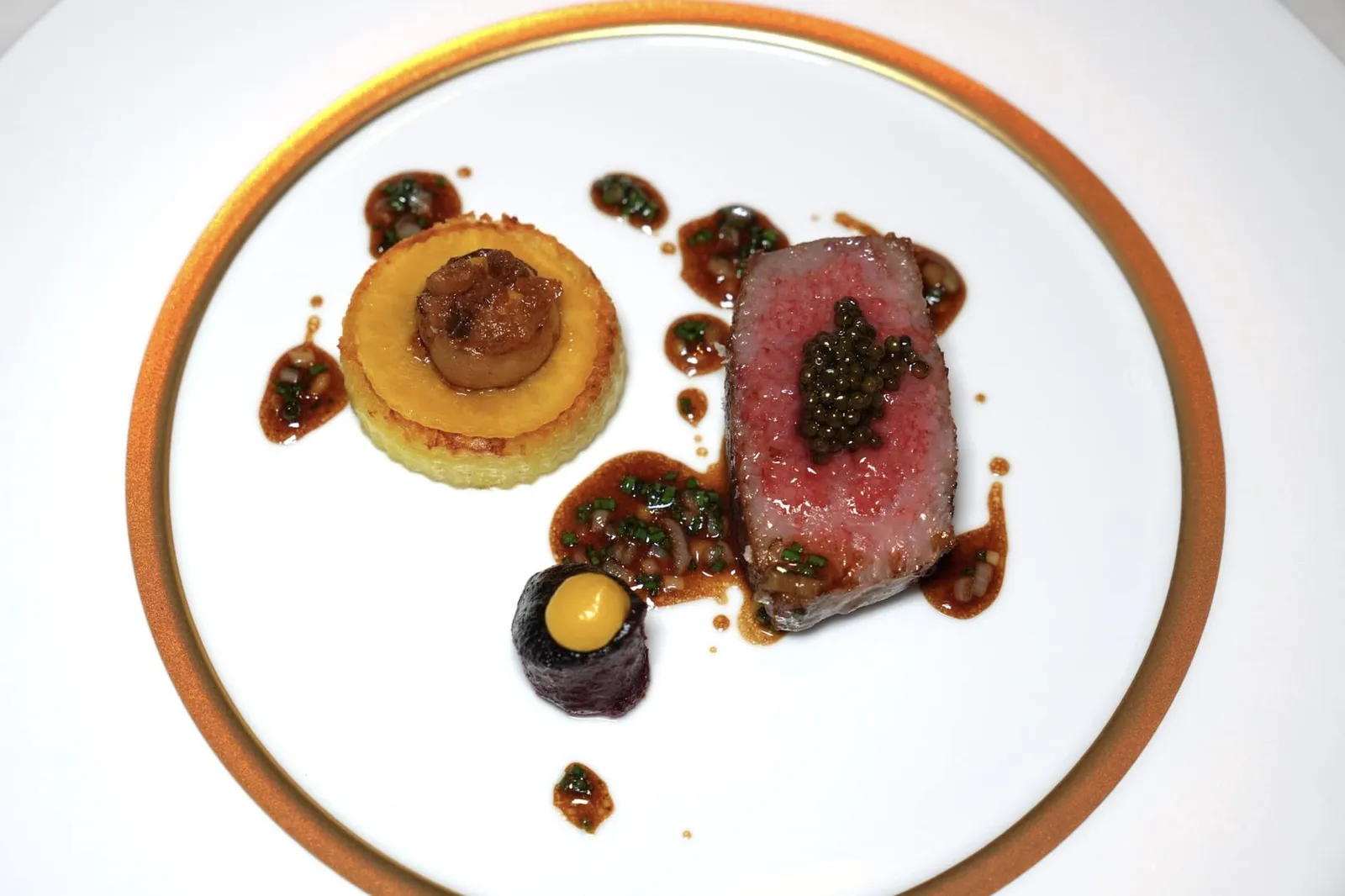 Wagyu Roasted with candied potato, steak tartare, bone marrow, Impérial caviar, green herbs and a red wine gravy เนื้อวัว Wagyu ระดับ A5 ย่างแล้วเสิร์ฟมาที่ความสุกระดับ Medium Rare เนื้อสัมผัสนุ่มละมุนจนแทบละลายในปาก ด้านบนท็อปด้วย Impérial Caviar ช่วยเสริมรสชาติให้มีมิติมากยิ่งขึ้น ข้างกันคือ Candied Potato มีลักษณะเป็นมันฝรั่งสอดไส้ตรงกลางด้วย Steak Tartare ยังมีองค์ประกอบของ Dry Aged Dutch Beetroot ที่นำ Dutch Beetroot ขนาดใหญ่ไปผ่านกระบวนการบ่มนานถึง 26 วันจนมีขนาดเล็กลงช่วยเพิ่ม Earthy Aroma ที่พอเหมาะยังมีองค์ประกอบ Piccalily Gel รสเปรี้ยว จากนั้นพนักงานจะเทราดซอส Red Wine Gravy ที่มีอโรมาหอม ๆ ของสมุนไพรลงไปเป็นอันพร้อมรับประทาน (19/20)