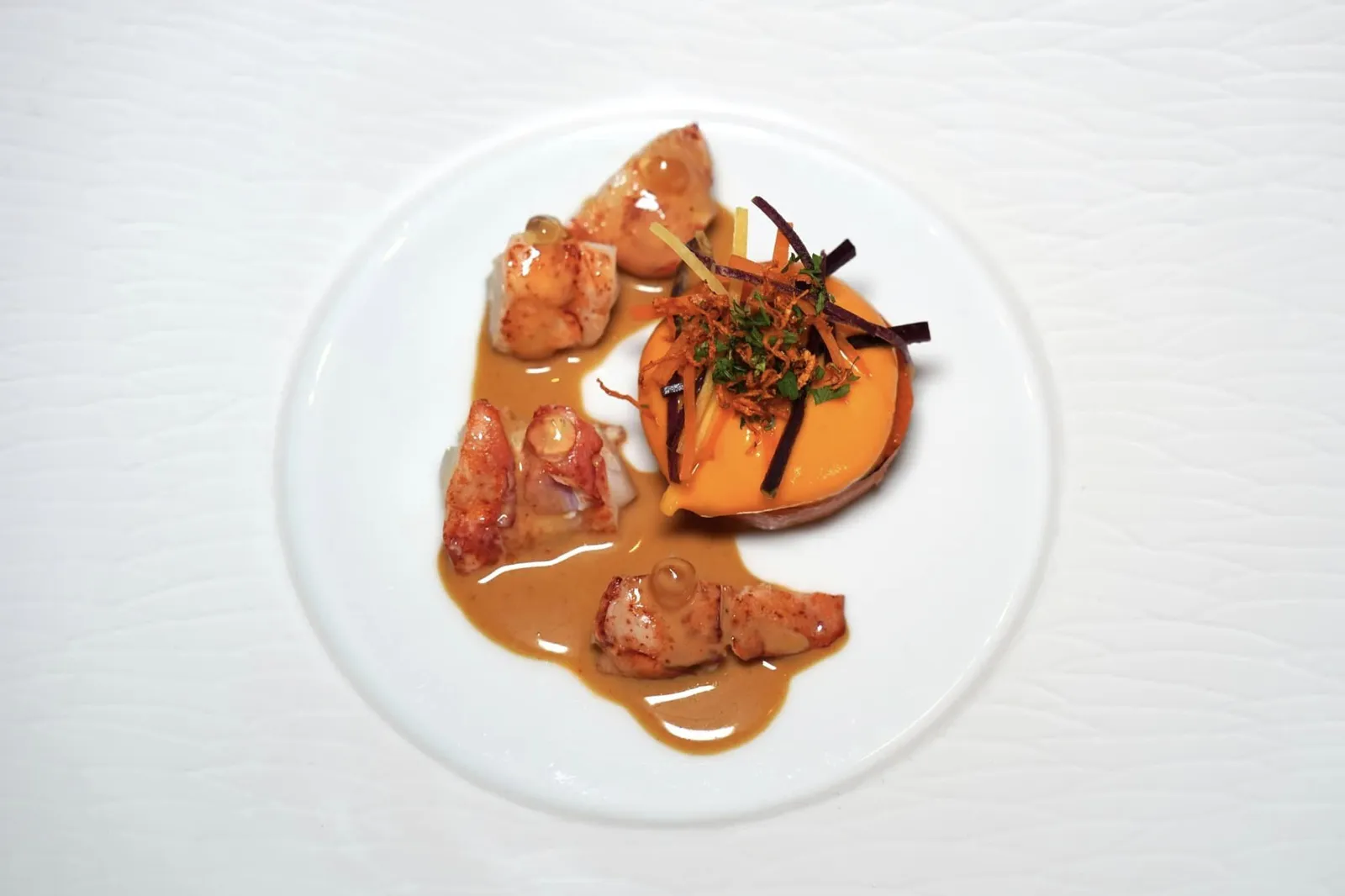 Lobster poached with stewed carrot, lobster salad, gel of ginger and a sauce of Tandoori องค์ประกอบข้างกันคือแครอทนำเสนอมาในหลากหลายรูปแบบที่แตกต่างกัน ด้านในเป็น Lobster Salad จากนั้นพนักงานจะเทราด Tandoori Sauce ให้กลิ่นหอมเฉพาะตัว (17/20)