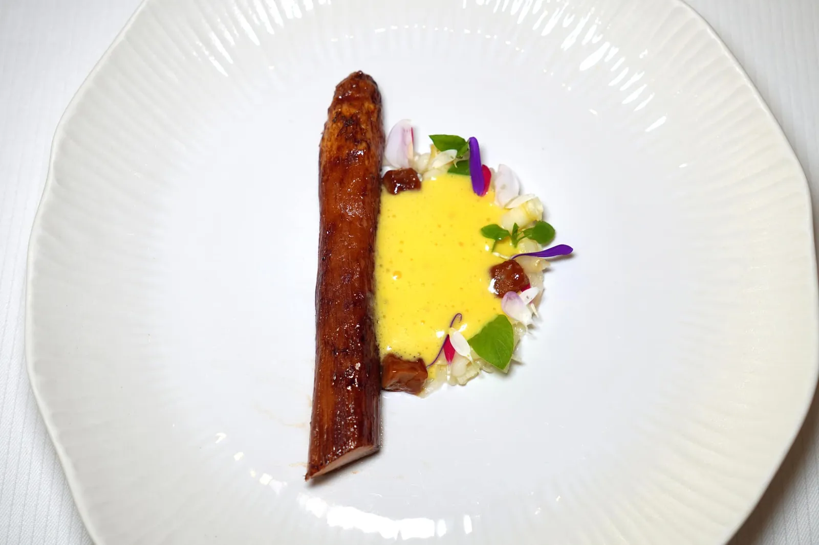 WHITE ASPARAGUS FROM VALAIS Madras curry and bitter orange blossom citron Buddha's hand ข้าง ๆ กันคือหน่อไม้ฝรั่งขาวสับเป็น Tartare เสริมด้วยรสเปรี้ยวของซิตรัส จากนั้นพนักงานจะเท Sabayon สีเหลืองสดที่มีอโรมาของแกงและและรสชาติเปรี้ยวขมของส้มลงไปในจาน (19/20)