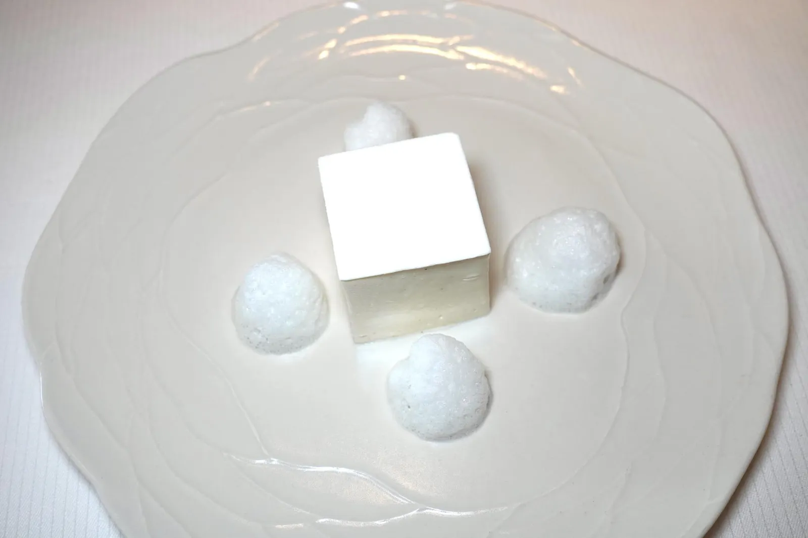 WHITE MILLE FEUILLE Tahitian vanilla cream jasmine jelly Voatsiperifery pepper foam Le Millefeuille Blanc เป็น Signature Dessert ที่เพียงจานเดียวที่มีติดอยู่ในรายการเมนูของห้องอาหาร Fine Dining ในเครือของเชฟ Anne-Sophie Pic ทุกแห่งโดยมีลักษณะเป็น Millefeuille ทรงลูกบาศก์สีขาวโมโนโครมขนาดประมาณ 125 ลูกบาศก์เซ็นติเมตรวางอยู่กลางจาน ภายในประกอบไปด้วยแป้ง Puff Pastry ขนาด 4 เซ็นติเมตรโรยด้วย Crystalline Jasmine นำมาเรียงกันเป็นเลเยอร์ทั้งหมด 3 ชั้นในแนวนอน แต่ละชั้นคั่นด้วย Jasmine Tea Jelly และ Tahiti Vanilla Chantilly คลุมรอบแผ่น Puff Pastry ออกอีกราวข้างละ 0.5 เซ็นติเมตรให้อโรมาหอมโดดเด่นและเนื้อสัมผัสนุ่มละมุนตัดกันกับความกรอบของแป้ง Puff Pastry ได้อย่างพอเหมาะ แผ่นสีขาวด้านบนคือ Royal Icing ทำมาจากไข่ขาว น้ำตาลไอซิ่ง และน้ำเลมอนให้รสชาติหวานนำโดยมีความขมตามมาเป็น Aftertaste สุดท้ายคือการเติม Voatsiperifery Foam Milk ที่ได้จากการนำ Voatsiperifery ซึ่งเป็นเครื่องเทศในกลุ่มพริกไทยจาก Madagascar ใส่ลงไปในน้ำนมเพื่อ Infused นานถึง 24 ชั่วโมงจนให้กลิ่นหอมเข้ากันดีกับความมันและครีมมี่ของนมเสริมมิติทางรสชาติ อโรมา และเนื้อสัมผัสกับ Millefeuille ได้อย่างไร้ที่ติ (20/20)