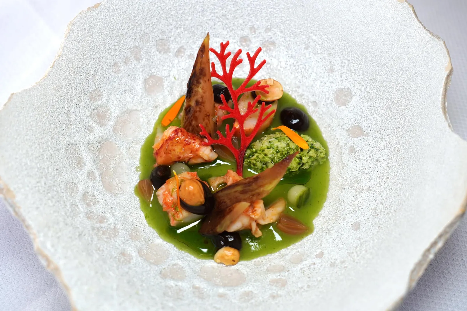 LANGOUSTINE & HAZELNUT Lobster, seaweed vinaigrette จานนี้คือเนื้อกุ้ง 2 ชนิดคือ Lobster และ Langoustine เตรียมมาสุกได้ระดับให้เนื้อสัมผัสที่นุ่มเด้งและรสหวานโดยธรรมชาติ เชฟใส่ถั่ว Hazelnut มาเพื่อให้มีความกรอบเสริมมิติทางเนื้อสัมผัส ยังมีองค์ประกอบของบล็อคโคลี่ รอบ ๆ คือซอสสีเขียวทำมาจากแตงกวาและสาหร่ายวากาเมะให้รสชาติเค็มเล็กน้อยนั่นเอง (16/20)