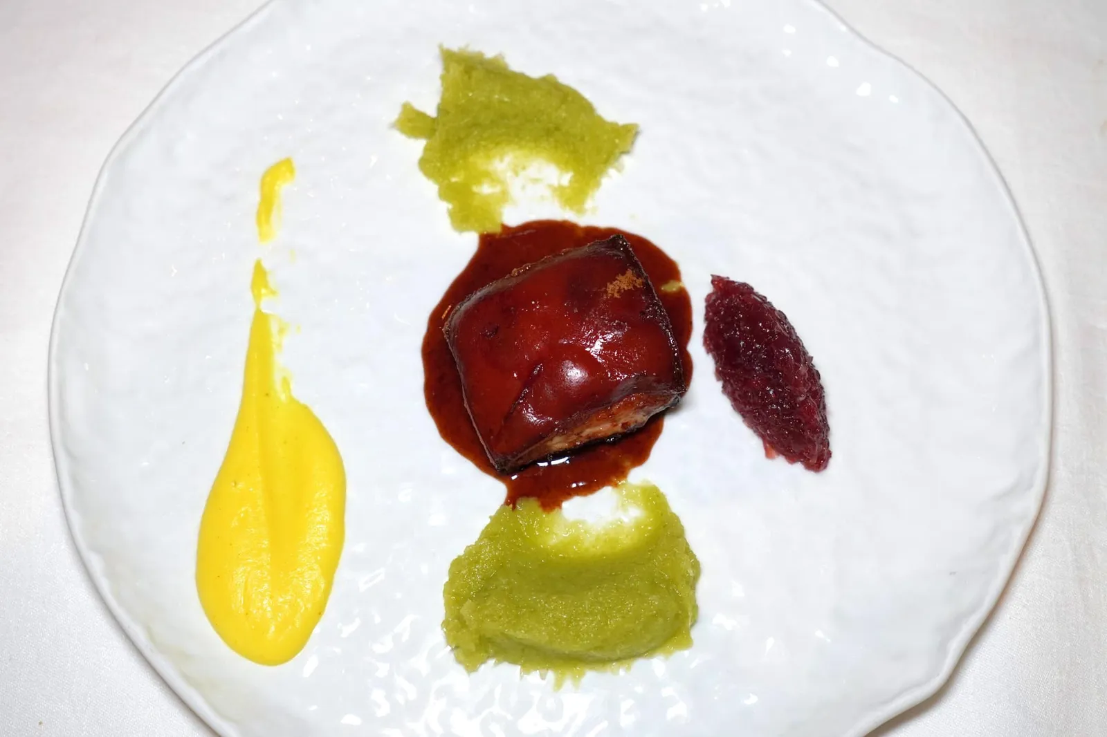 Suckling pig with crunchy rind, sweet and sour tamarind, celery, curcuma potato puree and chutney of red onions from Tropea หมูหันหรือเนื้อลูกหมูเสิร์ฟมาแบบเนื้อนุ่มหนังกรอบจับคู่กับ Tamarind Demi-glace หรือซอสสีน้ำตาลที่ได้รสชาติเปรี้ยวหวานเข้มข้นมาจากมะขาม Purée สีเขียวด้านบนและล่างของจานเตรียมมาจากเซเลอรี่ ส่วน Purée สีเหลืองอ่อนเตรียมมาจากมันฝรั่งและขมิ้น เสริมรสชาติด้วยองค์ประกอบฝั่งขวามือคือ Chutney ที่เตรียมขึ้นมาจาก Tropea Red Onion ซึ่งเป็นวัตถุดิบ IGP ขึ้นชื่อจากภูมิภาค Calabria ให้รสชาติอันแสนหวานกลมกล่อมแตกต่างจากหัวหอมแดงทั่วไปอย่างสิ้นเชิง (18/20)