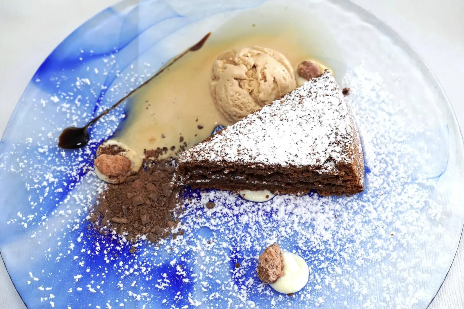 Torta caprese al cioccolato, gelato alla vaniglia (8 €) Caprese chocolate cake with vanilla ice cream ห้ามพลาดเมนูของหวานจานเด็ดประจำแถบนี้อย่าง Torta Caprese โดยตัวเค้กมีต้นกำเนิดมาจากเกาะ Capri และได้รับความนิยมไปทั่วทั้งพื้นที่แถบ Naples และ Amalfi Coast เนื้อเค้กมีความกรอบนอกนุ่มใน อร่อยชนิดที่หาใครเทียบได้ยาก ด้านบนโรยด้วยน้ำตาลไอซิ่ง แนะนำให้รับประทานกับไอศกรีมเพื่อตัดรสชาติกัน (14/20)