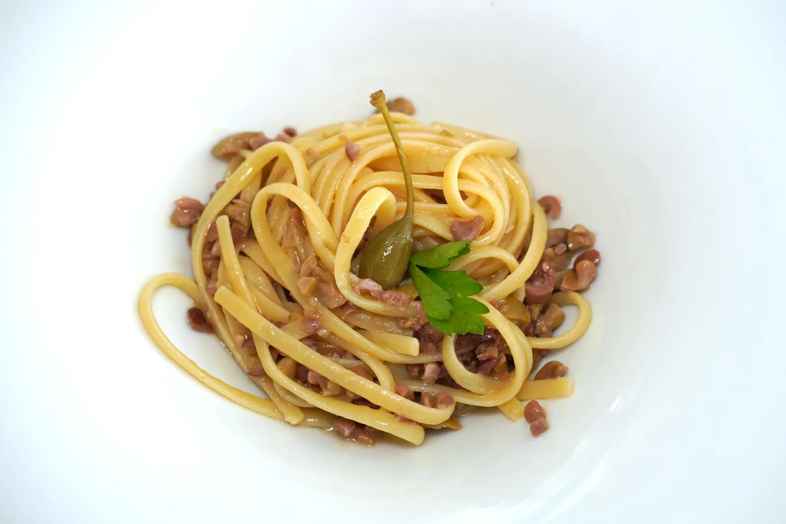 Linguine alla colatura di alici di Cetara secondo Erminia con olive verdi e nere, capperi, pinoli e noci (22 €) Linguine with anchovies extract from Cetara, green and black olives, capers, pine nuts and walnuts จานที่ดูแสนจะเรียบง่ายแต่เชฟกลับเตรียมออกมาได้ดีอย่างไม่น่าเชื่อคือพาสต้าเส้น Linguine ที่คลุกเคล้ามากับ Colatura di Alici di Cetara หรือน้ำปลาอิตาลีของดีจากเมือง Cetara ในพื้นที่แถบ Amalfi Coast โดยมีอโรมาเฉพาะตัวของเรเปอร์และมะกอกดำเสริมอยู่เบื้องหลัง ทั้งยังมีความกรอบที่ได้จากเมล็ดสนและถั่ววอลนัทอีกด้วย (14/20)