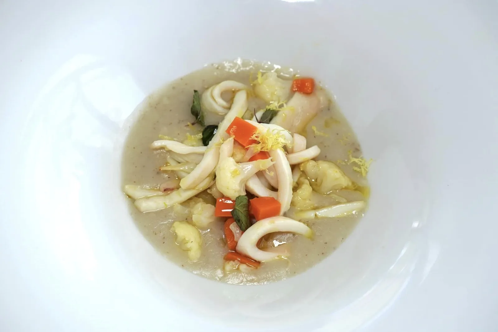Calamaro a julienne al Furore bianco e limone sfusato Amalfitano, verdure croccanti e vellutata di pane al rosmarino (18 €) Julienne squid with white Furore wine and sfusato Amalfitano lemon, crispy vegetables and bread sauce and rosemary หมึกกล้วยที่ถูก Julienne หรือหั่นเป็นชิ้นยาว ๆ ผัดกับไวน์ขาวท้องถิ่นของ Furore จนได้เนื้อสัมผัสนุ่มหนึบ เชฟเสิร์ฟมากับผักนานาชนิดให้รสชาติหวานโดยธรรมชาติก่อนจะตัดด้วยความเปรี้ยวของ Sfusato Amalfitano Lemon หรือเลมอนสายพันธุ์ท้องถิ่นของพื้นที่แถบ Amalfi Coast ด้านล่างคือซอสที่เจรียมมาจากขนมปังและโรสแมรี่นั่นเอง (13/20)