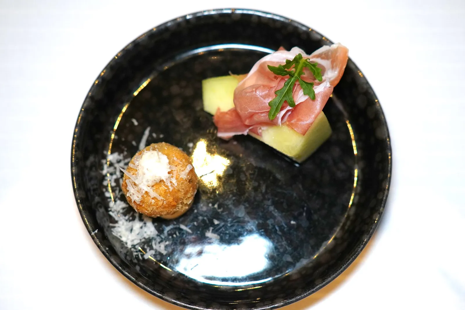 Amuse BoucheCantaloupe Melon, Aged Parma HamMushroom Aranciniเริ่มต้นมื้ออาหารด้วยของว่างเรียกน้ำย่อย 2 อย่างคือเมลอนท็อปด้วยพาร์ม่าแฮมที่มีความเข้มข้นอุมามิ อีกฝั่งหนึ่งคืออารันชินีที่มีข้าวปั้นเป็นก้อนกลมอยู่ด้านใน มีอโรมาหอม ๆ ของเห็ดเข้ากันกับความเค็มของชีสได้ดี