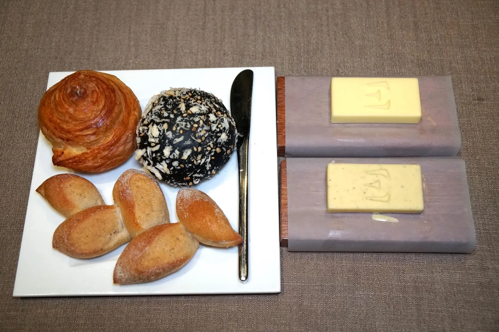 Charcoal Hokkaido milk, croissant roll, soba buckwheat Unsalted, smoked butter with miso ขนมปังที่นี่มีให้เลือก 3 อย่างคือ Japanese soft bun หรือขนมปังชาโคลสีดำนุ่มๆทำมาจากนมฮอกไกโด ทานเเล้วมีกลิ่นหอมนมชัดเจน ถัดมาคือครัวซองโรลสไตล์ฝรั่งเศส กรอบนอก นุ่มในตามมาตรฐาน สุดท้ายคือขนมปังบัควีทที่ทำมาจากเส้นโซบะมีเนื้อสัมผัสเหนียวหนึบกำลังดี ทานคู่กับเนยสองอย่างคือ Unsalted butter หรือเนยจืดจากประเทศฝรั่งเศสเเละ Smoked butter with miso เนยจืดเเบบเดียวกันที่นำไปรมควันกับเปลือกไม้ทานเเล้วจะมีกลิ่นหอมของเต้าเจี้ยวเเละสาหร่ายญี่ปุ่นด้วย