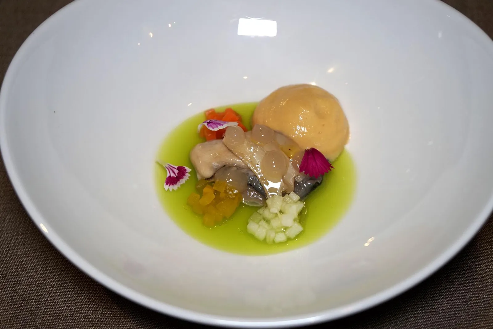 OSTRA REGAL Abalone, Apple เริ่มต้นจานเเรกในคอร์สด้วย Ostra Régal Oyster หรือหอยนางรมออสตร้ารีกัลสดๆจากฟาร์มชื่อดังในเมือง Saint-Coulomb แคว้น Brittany ประเทศฝรั่งเศส ทอปด้านบนด้วยเนื้อหอยเป่าฮื้อที่ผ่านการซูวีจนนุ่มหนึบ ช่วยเพิ่มมิติทางเนื้อสัมผัสเมื่อทานคู่กันกับตัวหอยนางรม เจลสีส้มอ่อนด้านบนก็ทำมาจากหอยเป่าฮื้อเช่นกัน เชฟทำองค์ประกอบของหอยเป่าฮื้อออกมาดีมาก ไร้ซึ่งกลิ่นคาวและรสเค็มใดๆ เจลสีเขียวด้านล่างมีส่วนผสมของผักเซเลอรี่และแอปเปิ้ลเขียวช่วยเรียกความสดชื่นให้กับจาน ข้างกันเป็นผักสามชนิดคือแอปเปิ้ลเขียวสด ทาคูอัน (Takuan - Japanese daikon) และแครอท องค์ประกอบสุดท้ายคือ Dashi espuma ที่เชฟนำดาชิหรือน้ำสต๊อกปลามาขึ้นเป็นโฟมสีส้มทางขวามือ ด้วยขนาดที่ค่อนข้างใหญ่พนักงานจึงเเนะนำให้ใช้มีดหั่นหอยเป็นสองชิ้นแล้วทานทุกองค์ประกอบพร้อมกัน การจับคู่หอยนางรมเข้ากับแอปเปิ้ลเขียวถือว่าเป็นพระเอก-นางเอกที่เกิดมาคู่กัน อย่างไรก็ตามแม้จะมีองค์ประกอบที่หลากหลายและหลายอย่างทำออกมาได้ดี เเต่น่าเสียดายที่แอปเปิ้ลเขียวซึ่งเป็นองค์ประกอบที่ช่วยเรียกความสดชื่นให้กับจานกลับไม่โดดเด่นมากนัก หากเชฟชูความโดดเด่นของแอปเปิ้ลออกมาเทียบเคียงกันกับหอยนางรมและให้ดาชิเอสปูม่าเป็นตัวเชื่อมสององค์ประกอบหลักเข้าด้วยกันจะทำให้จานนี้สดชื่น ช่วยเปิดต่อมรับรส และสมบูรณ์ขึ้นอีกมากเลยทีเดียว (14/20)