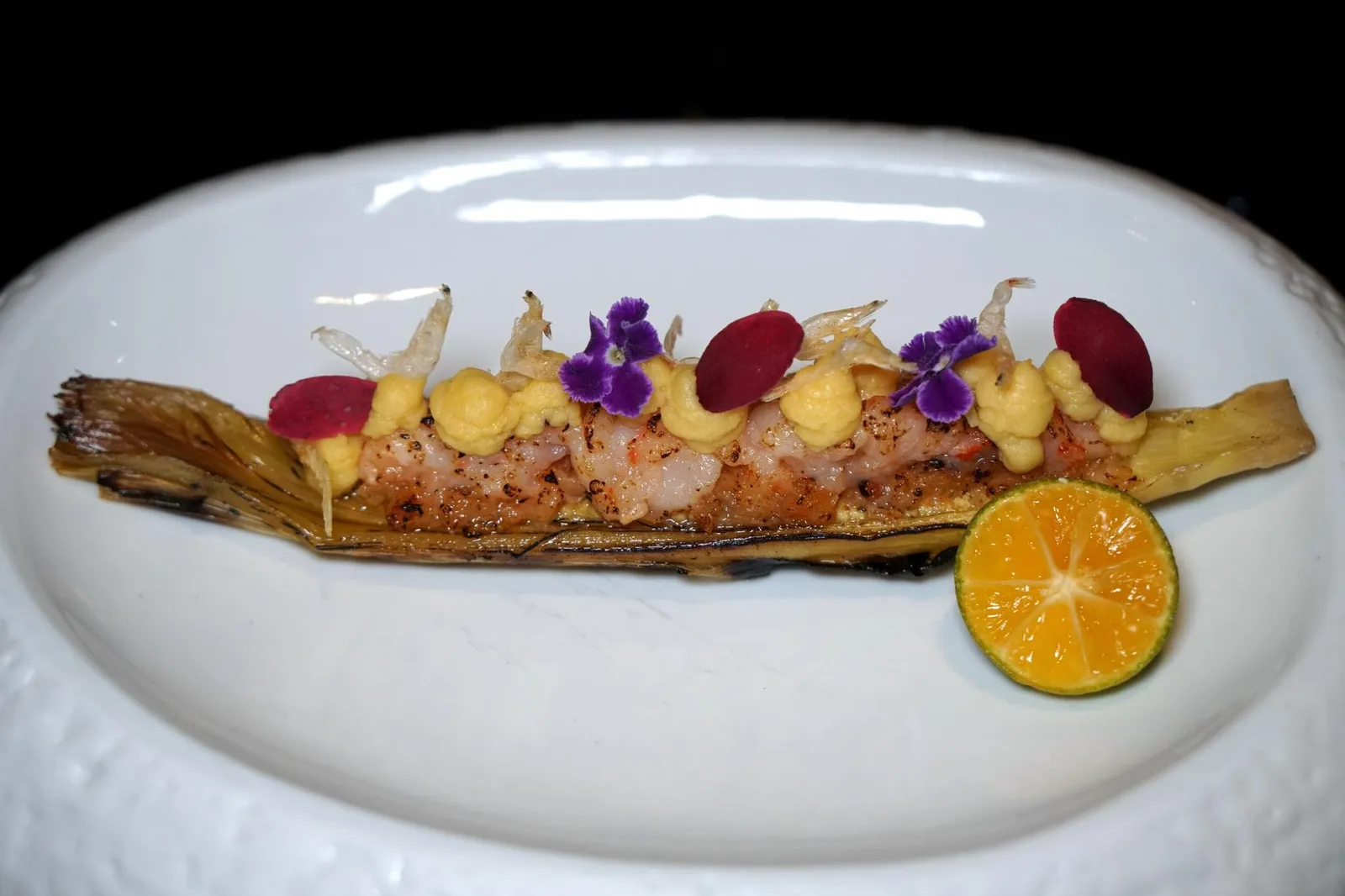 BABY CORN Grilled Organic Farmed Shrimp w/ Dried Shrimp Butter, Baby Corn, Smoked Corn Purée & Calamansi ถัดมาเป็นจานที่มีชื่อว่า “ข้าวโพดอ่อน” เกิดจากการจับคู่กันของวัตถุดิบหลัก 2 ชนิด อย่างเเรกคือกุ้งจากจังหวัดสุราษฎร์ธานีสับหยาบๆ จากนั้นจึงผ่านความร้อนบนน้ำมันหัวกุ้งจนสุก อีกองค์ประกอบหนึ่งคือเจลข้าวโพดรมควันสีเหลืองด้านบนเเละข้าวโพดอ่อนด้านล่าง อีกจุดเด่นคือกลิ่นหอมลอยเเตะจมูกตั้งเเต่ยกมาเสิร์ฟ ก่อนทานบีบส้มจี๊ดลงไปเพื่อปรับรสชาติให้สมดุลไม่ให้เลี่ยนได้ง่าย (ตรงนี้เราประทับใจเลยว่าเชฟบาลานซ์รสชาติมาดีมากเพราะถ้าจบเเค่กุ้งกับเนยจานนี้ก็จะไม่โดดเด่นมากนัก) เชฟย้ำอีกว่าตอนทานให้ตักส่วนของใยข้าวโพดติดไปด้วยเนื่องจากตัวใยข้าวโพดสามารถเพิ่มความหอมเเละรสอุมามิทำให้จานนี้สมบูรณ์ที่สุด (13/20)