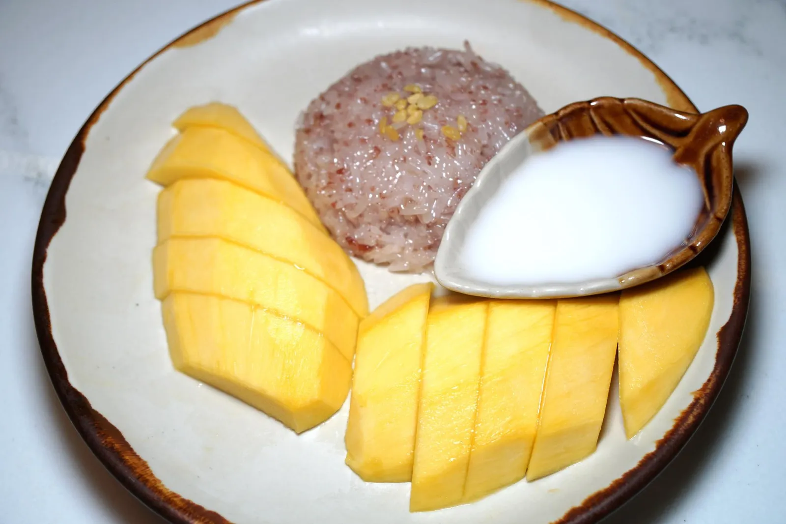 ข้าวเหนียวมะม่วง (290++) Coconut sticky rice with mango (seasonal) มาทานอาหารไทยของหวานที่ขาดไม่ได้คือข้าวเหนียวมะม่วง ตัวข้าวเหนียวทำออกมาได้ดีมากๆ มีความนุ่ม ละมุน เนื้อสัมผัสไม่เหนียวจนเกินไป จนเราเเอบว้าวเลยทีเดียว น่าเสียดายที่มะม่วงวันนี้เป็นมะม่วงนอกฤดูกาลทำให้มีรสชาติค่อนข้างเปรี้ยวโดดไปหน่อย (12/20) (ถ้ามะม่วงหวานดีจานนี้น่าให้ 13 คะเเนนได้เลยเพราะข้าวเหนียวดีงามมากๆ)