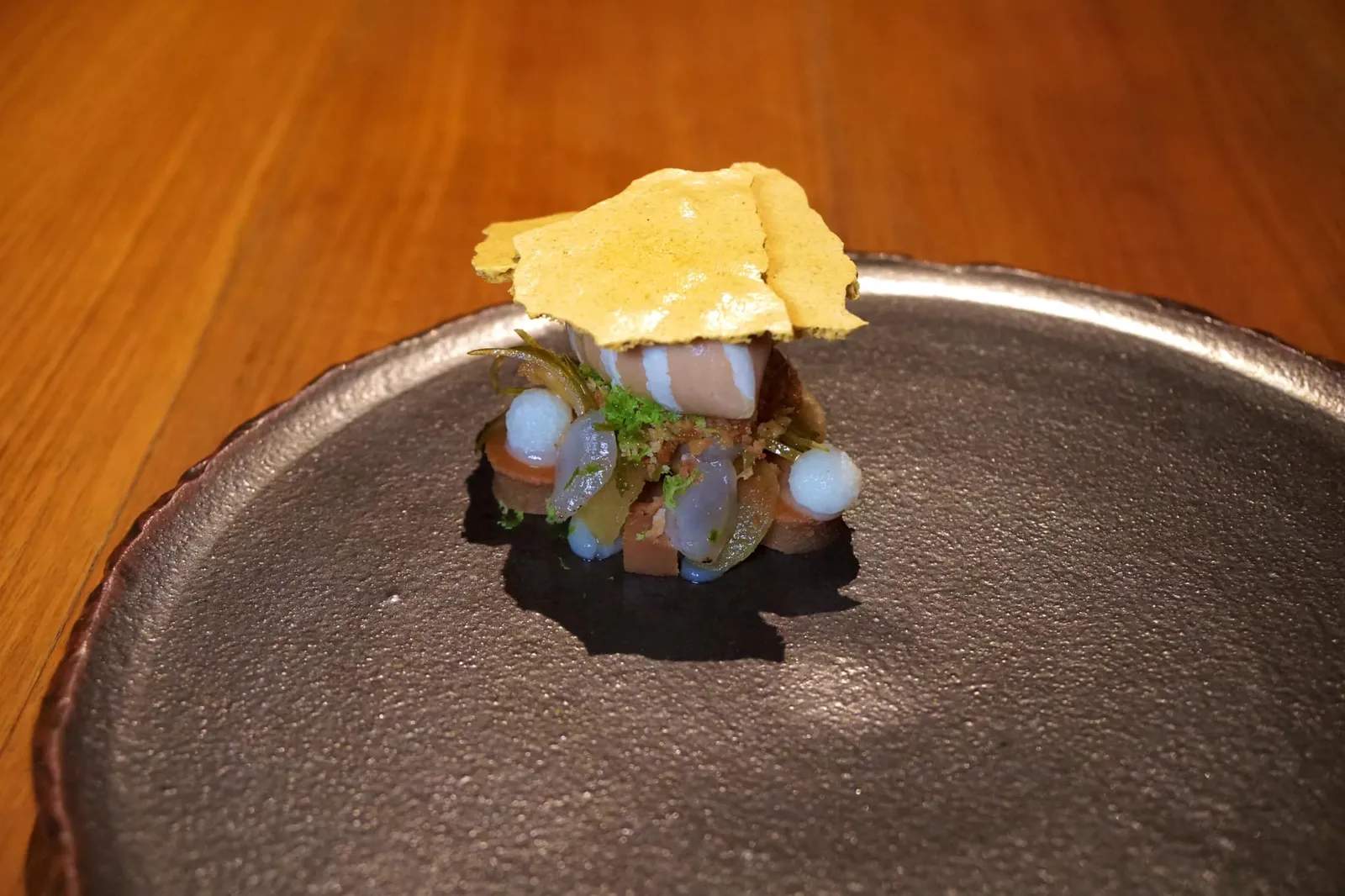 Chef's favorite from Chiang Mai Jicama and longan หนึ่งในจานที่เชฟกล้าลองเสี่ยงมากที่สุดในมื้อนี้คืออาหารหวานจานสุดท้ายในเซ็ทเมนู 7 คอร์สที่นำวัตถุดิบหลักของแกงกะหรี่มาทำเป็นอาหารหวาน เริ่มจากแผ่นเมอแรงก์กรอบด้านบนทำมาจากผงกะหรี่ ตรงกลางคือไอศกรีมลิ้นจี่ผสมกับลำไย มีเนื้อมันแกวช่วยเพิ่มความกรอบ มีขิงและเปลือกมะนาวที่นำมาทำเป็นครัมเบิ้ล รองด้านล่างด้วยเค้กน้ำตาลมะพร้าว ทานเเล้วจะได้กลิ่นหอมของแกงกะหรี่ ความหวานของลำไย ตัดด้วยความเผ็ดของขิงซึ่งดูจะแรงมากไปนิด ถือเป็นอาหารหวานที่ซับซ้อนเเละน่าจะถูกใจเหล่า Foodies มากๆ กลับกันใครที่มาทานเเล้วคาดหวังอาหารหวานที่ตรงไปตรงมาเพื่อปิดท้ายคอร์สอาหารคาวอาจไม่ชอบสักเท่าไหร่ (16/20)