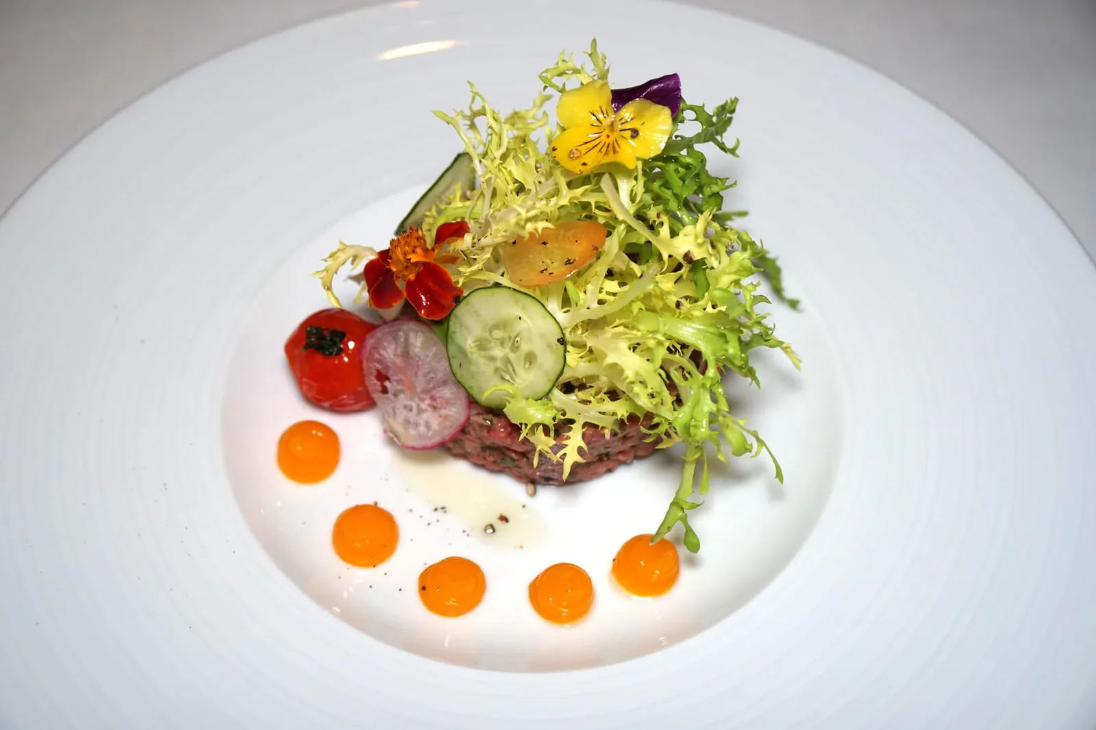 HAND-CHOPPED BEEF TARTARE (750++) Our version of the tartare | Egg yolk | Cornichon | Shallots | Green olives นำมาจัดเสิร์ฟให้เป็นทรงดูน่าทาน ทอปด้านบนด้วยผักต่างๆ ราดด้วยน้ำมันมะกอกนิดหน่อย ข้างกันคือมะเขือเทศกงฟี หยดสีส้มได้มาจากไข่แดงที่ตีกับมัสตาร์ด (14/20)