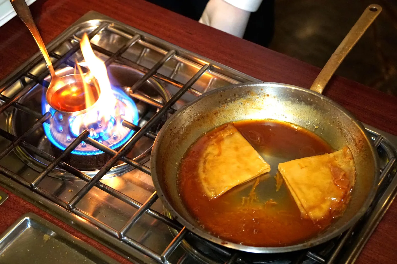 CLASSIC CREPES SUZETTE (450++) Vanilla ice cream | Orange segments | Cointreau | Martell VSOP ตามด้วยการใส่ผิวส้มที่หั่นเป็นชิ้นเล็กๆแล้วผ่านการต้มในน้ำเชื่อม ใส่แป้งเครปลงไป หมุนกระทะ และตักน้ำซอสราดให้ทั่วถึงทุกรอยพับของเครป เคี่ยวจนน้ำซอสงวดเพื่อให้ได้รสชาติที่เข้มข้น (15/20)