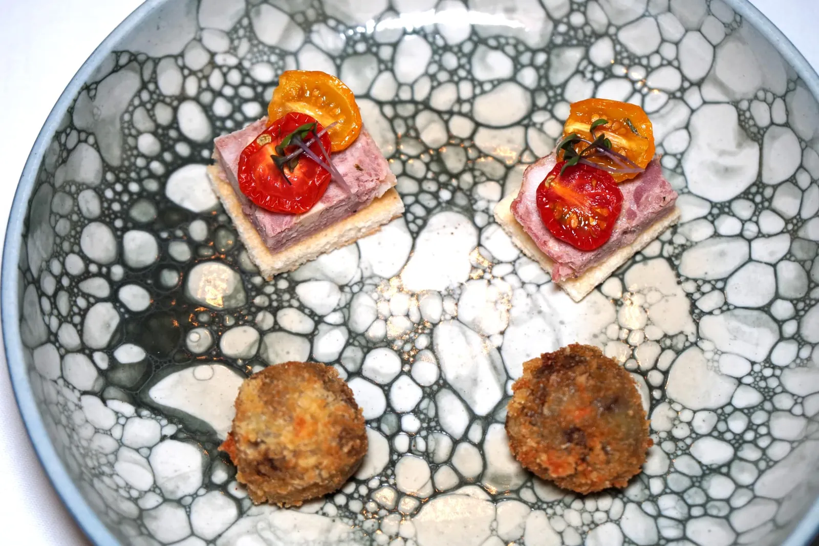 AMUSE BOUCHE Pork Terrine | Beef Rillette Croquettes เริ่มต้นมื้ออาหารด้วยอมูสบูชนำเสิร์ฟ 2 อย่าง ชิ้นบนเป็น Pork Terrine เนื้อนุ่ม แน่น หอม เสิร์ฟมาในอุณหภูมิเย็นพอเหมาะ ด้านล่างเป็นขนมปัง ส่วนด้านบนทอปด้วย Sun Dried Tomato เพิ่มความเปรี้ยว อุมามิเบาๆตัดกับความมันของเทอร์รีนได้อย่างดี (13/20) อีกชิ้นหนึ่งคือ Beef Rillette Croquettes เชฟนำเนื้อวัวไปตุ๋นจนเปื่อยนุ่ม จากนั้นนำไปชุบขนมปังทอดจนกรอบ กัดเข้าไปกลิ่นหอมของเนื้อตุ๋นจะระเบิดออกมาในปาก อร่อยใช้ได้เลย (13/20)