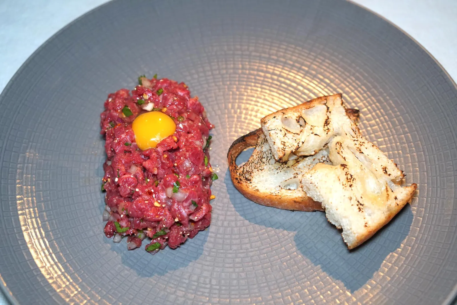 SPICY WAGYU TARTARE ‘LAAB’ (950++) Dark Soy / Bird's Eye Chilli / Roasted Sesame Oil มาที่ร้าน Eat Me จะพลาดไม่ได้กับเมนูแนะนำอย่างทาทาร์เนื้อสไตล์ไทยที่เชฟใช้เนื้อวัวออสเตรเลียนวากิวมาสับจนละเอียด เนื้อสัมผัสนุ่มดีมาก จากนั้นใส่น้ำมันงาคั่ว ซีอิ๊ว ข้าวคั่ว หอมแดง และพริกขี้หนูสวนลงไป ทานแล้วจะให้รสชาติจัดจ้านคล้ายก้อยหรือลาบดิบบ้านเรา คลุกไข่แดงของไข่นกกระทาด้านบนเข้าด้วยกันซึ่งทำหน้าที่เป็นตัวเชื่อมแต่ละองค์ประกอบ ตักใส่ขนมปังกรอบแล้วทาน อร่อยสมกับเป็นเมนูแนะนำเลยล่ะ (13/20)