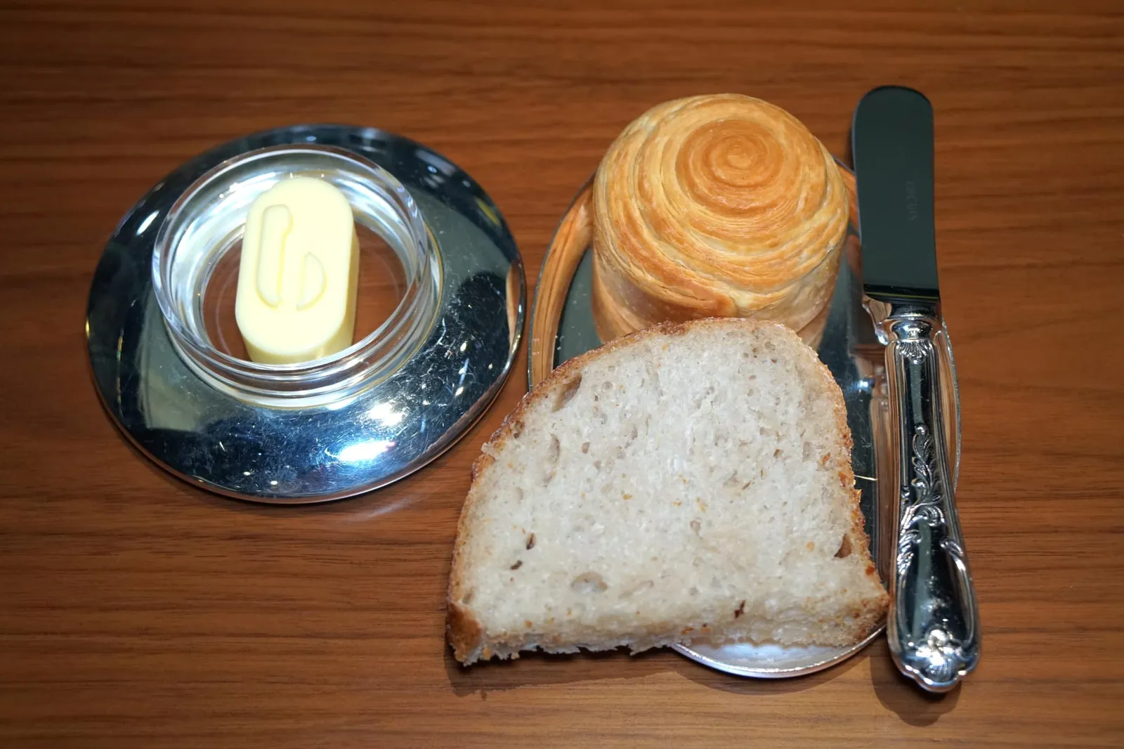 Brioche and sourdough ขนมปังเสิร์ฟมาให้ทานคู่กับเนย Beillevaire Demi-sel Butter จากตะวันตกของประเทศฝรั่งเศส เป็นเนยที่ได้จากการผสมน้ำนมวัวดิบใน Churn หรืออุปกรณ์ทำเนยแบบดั้งเดิมจึงมีเนื้อสัมผัสนุ่ม มีความครีมมี่และความมันที่พอเหมาะ ทั้งยังมีรสเค็มที่ได้จากการผสม Fleur De Sel หรือดอกเกลือที่ได้จากการนำเกลือไปแช่ในบ่อและปล่อยให้ลมเย็นไหลผ่านบริเวณผิวตั้งแต่ช่วงเย็นก่อนที่จะเก็บผลผลิตในเช้าวันรุ่งขึ้นด้วยมือและอุปกรณ์ไม้แบบดั้งเดิม เมื่อนำมาผสมเข้ากับเนยจึงมีรสเค็มกลมกล่อมปนมาเพียงเบาๆ ถือเป็นหนึ่งในเนยที่ดีที่สุดในประเทศฝรั่งเศสเลยก็ว่าได้