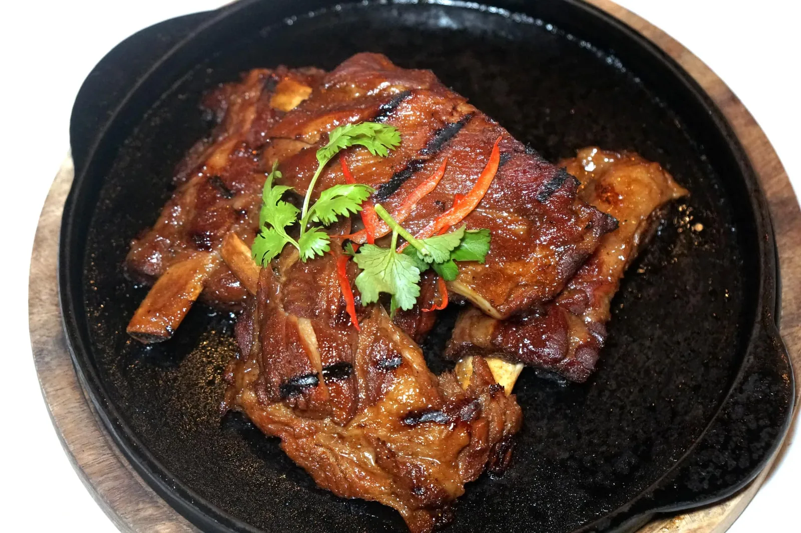 กระดูกหมูย่างน้ำผึ้ง (880++) BLUE ELEPHANT FAMOUS GRILLED SPARE RIBS & SOM TUM 45 years secret recipe; Organic Thai Local Ribs - our Unique 24 hours Marination - Khao Kua - “I-Sarn” Chilli Dip - Spicy Thai Herns - Som Tum - Sticky Rice. เมนูที่ฟังดูง่ายๆ แต่กลัเป็นจานที่สร้างชื่อให้กับร้าน Blue Elephant มานานถึง 45 ปี คือกระดูกที่หมักกับน้ำผึ้งและเครื่องเทศนานถึง 24 ชั่วโมง จากนั้นนำไปย่างจนหอมกลิ่นถ่าน เนื้อหมูนุ่มละมุนมากๆจนแทบไม่อยากเชื่อว่าเชฟใช้เนื้อหมูท้องถิ่นของประเทศไทย เสิร์ฟมาบนกระทะร้อน แล่เป็นชิ้นพร้อมตักทาน (15/20)