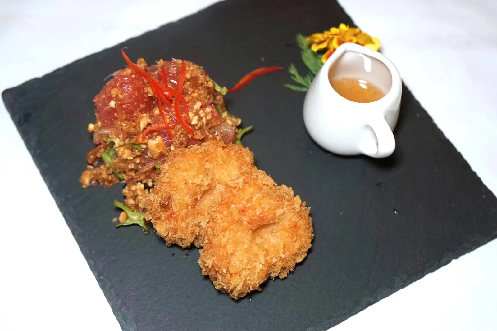 ทอดมันกุ้งกับยำส้มโอทับทิมสยามเมืองคอน (420++) “TABTIM SIAM” CRISPY PRAWN CAKE Deep Sea Tiger Prawn Cakes - Hint of organic Thai Garlic - Side of refreshing - Nakhon Si Thammarat “Tabtim Siam” Pomelo salad. อีกหนึ่งจานที่เราประทับใจที่สุดจานการแวะมาทานครั้งก่อนคือยำส้มโอสูตรพิเศษที่เชฟนูรอใช้ส้มโอทับทิมสยามซึ่งเป็นของดีจากจังหวัดนครศรีธรรมราชแกะออกเป็นชิ้นๆ ตัวส้มโอมีสีชมพูดูน่าทาน ตักเข้าปากจะได้รสหวานนำอมด้วยรสเปรี้ยวนิดๆ สดชื่นมากๆ ยังไม่พอเท่านั้นเพราะยังมีทอดมันกุ้งชั้นดีที่ใช้เนื้อกุ้งลายเสือมาเป็นวัตถุดิบหลัก ผิวด้านนอกกรอบ เนื้อด้านในเด้ง มีกลิ่นหอมกุ้ง ทานกับซอสหวาน ถือเป็นหนึ่งในเมนูยำส้มโอที่ดีที่สุดในกรุงเทพอย่างไม่ต้องสงสัย (15/20)
