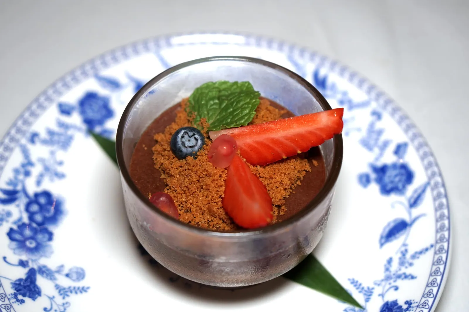 ช็อคโกแลตมูส (240++) CHOCOLATE MOUSSE A recipe brought back from Blue Elephant Brussels. Made with Dark Belgian “70% Callebaut” Chocolate. ที่มาของขนมหวานอย่างช็อกโกแลตต้องย้อนไปเมื่อเชฟนํรอเปิดร้าน Blue Elephant สาขาแรกที่กรุง Brussels เมื่อกว่า 40 ปีก่อน ณ เวลานั้นขนมไทยยังไม่เเพร่หลายในยุโรป เชฟนูรอจึงใช้วัตถุดิบท้องถิ่นระดับโลกของประเทศเบลเยี่ยมอย่างดาร์คช็อกโกแลต Calebaut 70% มาทำเป็นมูสเนื้อเนียนละมุน มีรสขมนิดๆ และมีกลิ่นหอมเด่นขึ้นจมูก ทานกับช็อกโกแลตครัมเบิ้ลกรอบเเละผลเบอร์รี่สดเข้ากันได้ดี (13/20)