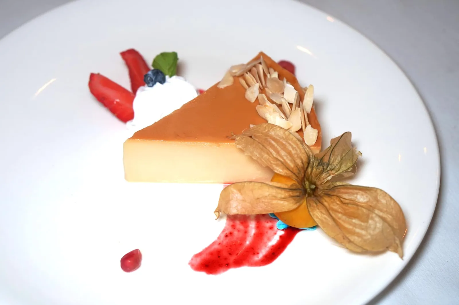 คัสตาร์ดมะพร้าว (180++) COCONUT FLAN Creation from Blue Elephant Brussels: Creamy Caramelized Coconut Flan topped with sprinkles of grilled Isaan Almond Flakes. เช่นเดียวกับมูสช็อกโกแลต ขนมฟลานเป็นเมนูที่เชฟนูรอนำข้ามกาลเวลามาจากร้าน Blue Elephant สาขากรุง Brussels เเต่เพิ่มความเป็นไทยโดยการใส่มะพร้าวลงไปด้วย เนื้อฟลานเนียนนุ่ม หอมกลิ่นมะพร้าว ผิวด้านบนถูกคาราเมลไลซ์มาพอดีให้รสขมเพียงนิดๆตัดกับความหวานได้อย่างลงตัว ทานกับวิปปิ้งครีม ถั่วอัลมอนต์ฝาน เบอร์รี่ และผลโทงเทง (13/20)