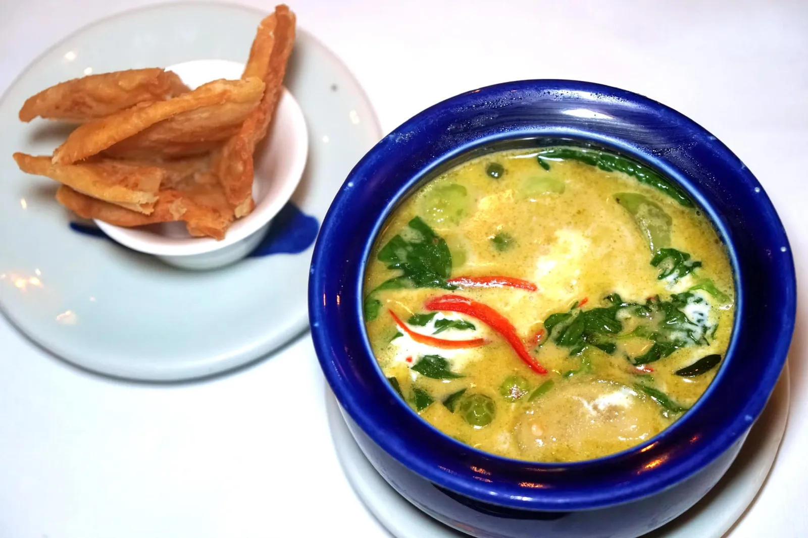 แกงเขียวหวานไก่พริกขี้หนูสวน โรตีกรอบ (420++) COCOCABANCHICKEN GREEN CURRY Southern Style Green Curry, Chicken poached in coconut milk, kaffir lime leaves, Thai sweet basil leaves, bird's eye chilli and fresh turmeric จานสุดท้ายของเมนูแกงคือแกงเขียวหวานที่เชฟนูรอแอบใส่กลิ่นอายของคนใต้ลงไปด้วยคือมีรสชาติเผ็ดจัดจ้าน มีกลิ่นเฉพาะตัวของขมิ้น โปรตีนหลักอย่างเนื้อไก่ผ่านการโพชมาในน้ำมะพร้าวอย่างดีจนนุ่ม เพียงใช้ลิ้นดันเบาๆก็แตกออกจากกัน อย่างไรก็ตามเรารู้สึกว่ารสชาติหวานที่อยู่ในจานน้อยไปนิดจึงไม่ค่อยบาลานซืกับความเผ็ดเท่าไหร่นัก เมื่อทานคู่กับโรตีบอกเลยว่าอร่อยไม่เบาแต่ยังไม่โดดเด่นเทียบกับ Signature Curry สองอย่างก่อนหน้านี้ (14/20)
