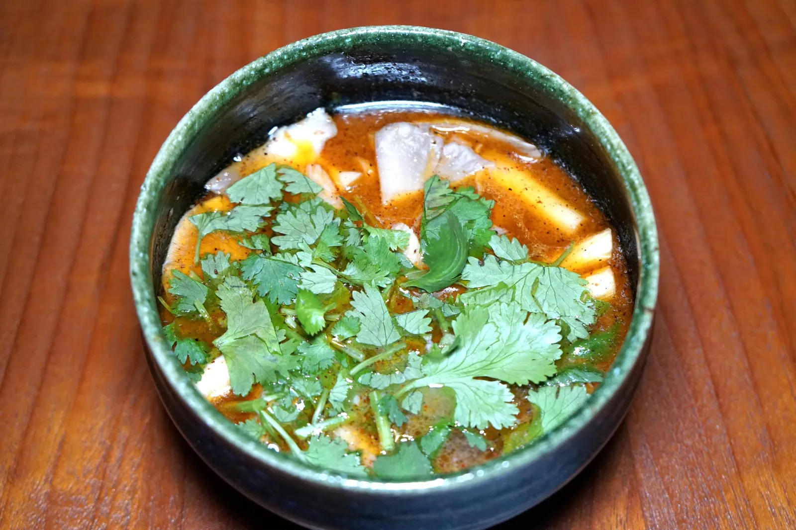 ต้มยำกุ้งกับเห็ดป่า (450++) Tom yum soup of river prawn, wild mushroom and chili jam “ต้มยำกุ้ง” ที่ร้านน้ำได้จากการนำหัวกุ้งไปเคี่ยวเพื่อทำเป็นน้ำสต็อกก่อน จากนั้นจึงเคี่ยวส่วนมันกุ้งใส่ลงไปเพื่อเพิ่มความเข้มข้น เชฟใส่เห็ดป่าลงไปช่วยเพิ่มความหลากหลายทางเนื้อสัมผัส อีกหนึ่งวัตถุดิบสำคัญคือน้ำพริกเผาที่ทางร้านทำเองซึ่งมีกลิ่นหอมเด่นชัดเจนเสริมกันกับมันกุ้งแต่ไม่มากเกินไปจนเลี่ยน รสชาติโดยรวมไม่จัดจ้านแต่กลมกล่อมและแฝงความเป็นผู้ดีเอาไว้อย่างแนบเนียน (14/20)