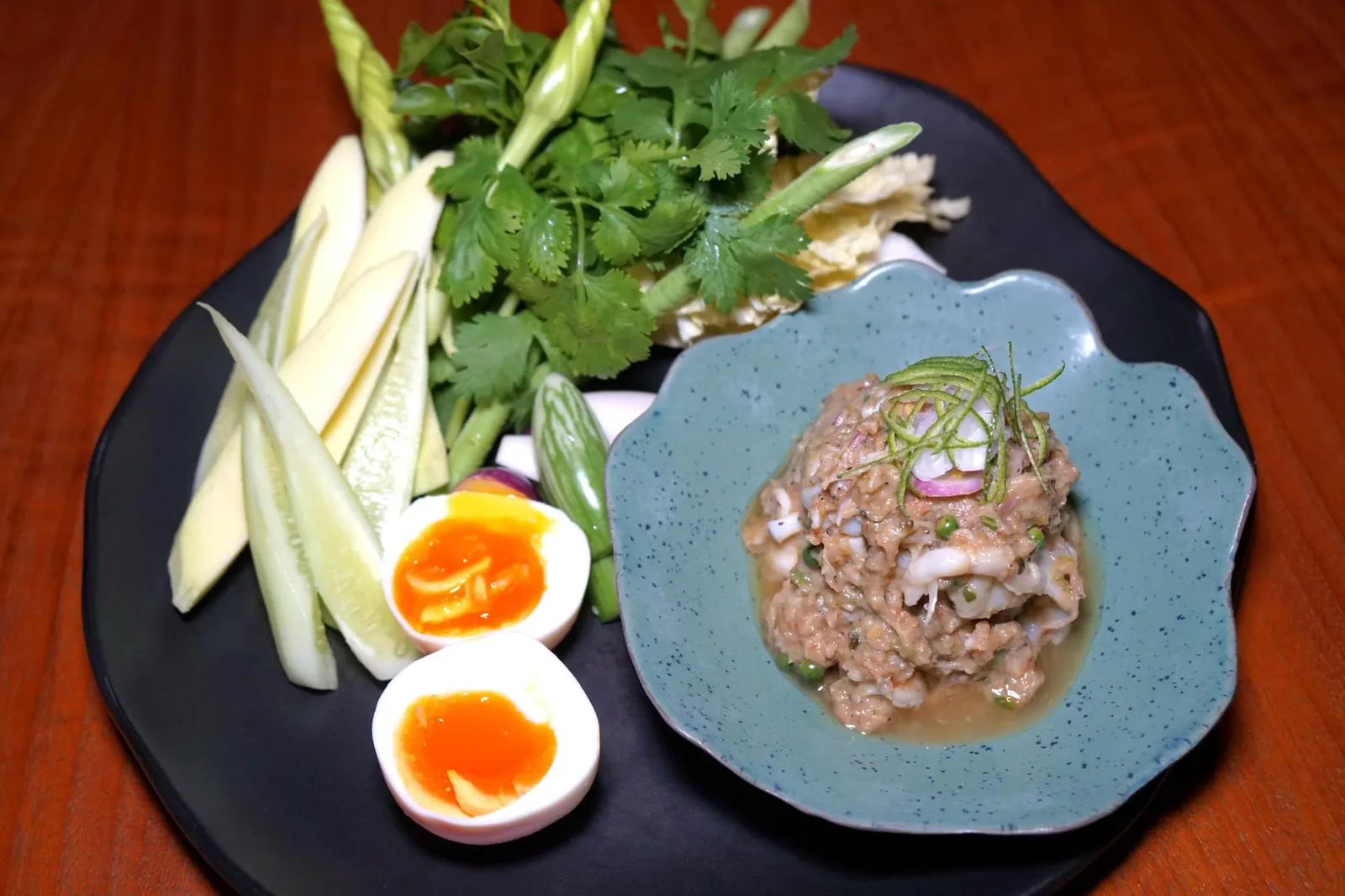 กะปิพล่าพริกไทยอ่อน (760++) Relish of wild prawns from Songkla, Chumpon shrimp paste and green peppercorn หนึ่งในเมนูที่ดีที่สุดในค่ำคืนนี้ขอยกให้ “กะปิพล่าพริกไทยอ่อน” เมนูเครื่องจิ้มชั้นดีที่ใช้โปรตีนหลักเป็นเนื้อกุ้งลายเสือสดๆที่ได้มาจากชาวประมงท้องถิ่นจังหวัดสงขลามาคลุกเคล้ากับกะปิชั้นดีจากจังหวัดชุมพร เสิร์ฟมาคู่กับไข่ไก่ออร์แกนิคยางมะตูม มะม่วงมัน ดอกชมจันทร์ แตงกวา มะเขือ ผักชีไทย ผักชีล้อม ผักกาดขาว ถั่วฝักยาว และใบน้ำ (15/20)