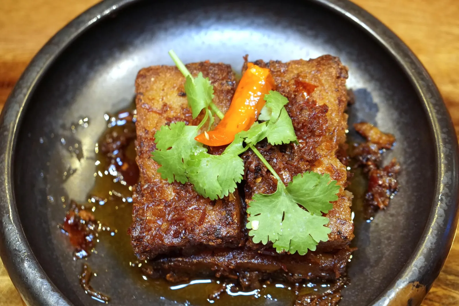 ขนมผักกาดเอ็กซ์ตร้าโอลด์คอนญัก (150++) Pan Fried Turnip with X.O. Sauce ขนมผักกาดเป็นเมนูอาหารจีนพื้นบ้านที่เราคุ้นเคยกันดี เชฟนำกังป๋วย แฮมยูนนาน กระเทียม พริกไทยดำ พริกแห้ง และน้ำมันถั่วเหลือง มาเคี่ยวกับบรั่นดีจีนจนงวดเป็นซอส X.O. สูตรพิเศษ รสชาติเข้มข้นเข้ากันกับเนื้อสัมผัสที่ดีของขนมผักกาด รับรองว่าใครได้ทานเป็นต้องติดใจ (14/20)