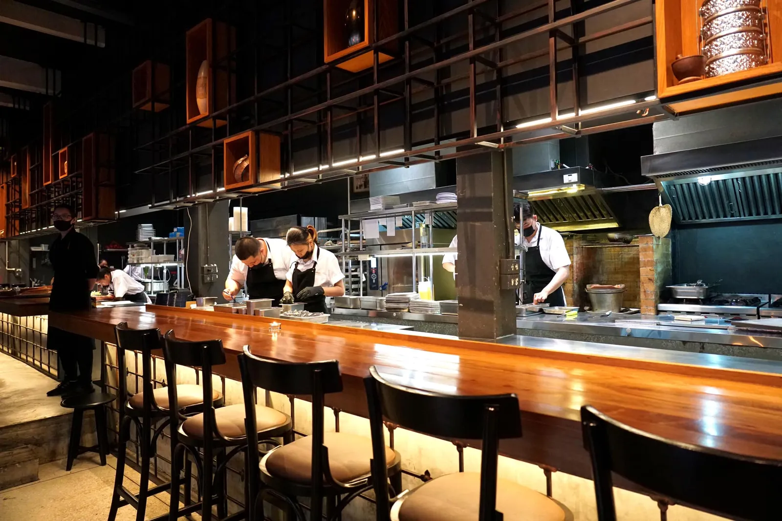 ผนังฝั่งซ้ายริมถนนถูกกั้นด้วยกระจกใสทำให้ร้านดูโปร่ง โล่ง ไม่อึดอัดตา ฝั่งขวาเป็นครัวขนาดใหญ่ที่กินพื้นที่เกือบครึ่งหนึ่งจากทั้งหมด