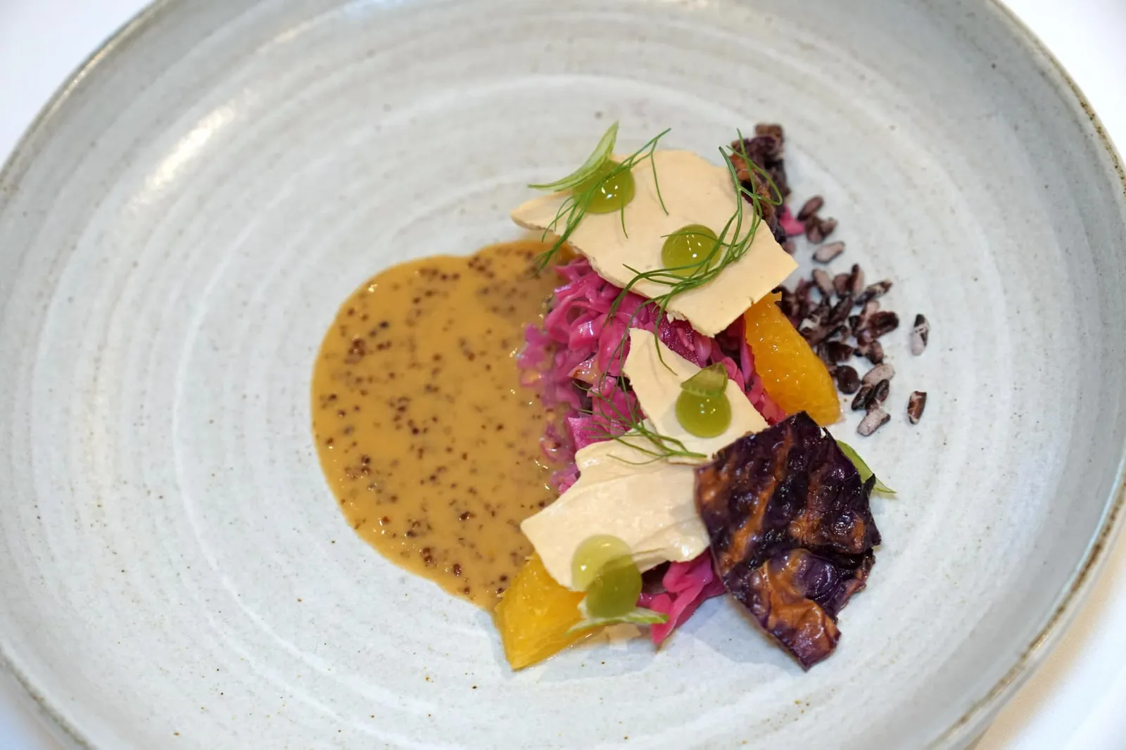 DUCK A L'ORANGE foie gras | red cabbage | fennel จานนี้เชฟแดนได้นำเมนูฝรั่งเศสคลาสสิคอย่าง “เป็ดซอสส้ม” มาดัดแปลงให้ออกมาในรูปแบบของตัวเองโดยการนำเนื้อเป็ดไปกงฟีแล้ววางอยู่ที่ด้านล่างสุด ข้างกันคือส้มที่หั่นเป็นชิ้นขนาดพอดีคำ ตรงกลางคือกะหล่ำปลีดองสีแดงที่เชฟตั้งใจเพิ่มตัวตนความเป็นเกาหลีลงไป ด้านบนเป็นแผ่นกรอบสีแดงเข้มทำมาจากกะหล่ำปลีแดงเช่นกัน ขนาบข้างด้วยแผ่นสีส้มอ่อนทำมาจากฟัวกราส์ให้เนื้อสัมผัสคล้ายเมอแรงก์แล้วทอปด้วยเจลสีเขียวทำมาจากเฟนเนล ดอกเฟนเนล และเฟนเนลซอยมาเป็นชิ้นเล็ก ๆ ด้านข้างคือ Puffed riceberry ช่วยเพิ่มความกรอบ จบด้วยการเทซอสมัสตาร์ดลงไปในจาน (16/20)
