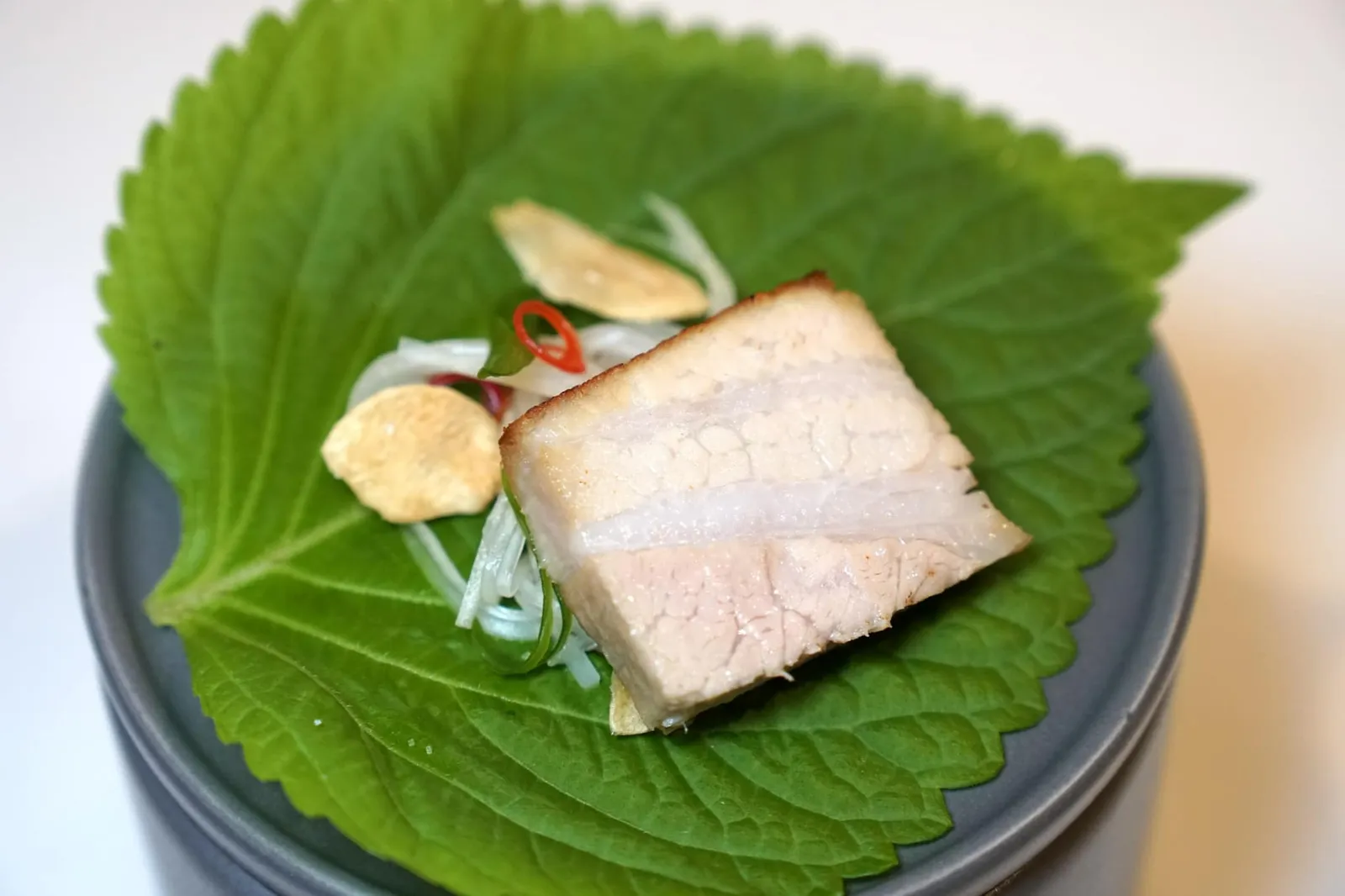 CHILDHOOD pork belly | saamjang sauce | kimchi วิธีทานให้ใช้ตะเกียบคีบหมูมาวางลงบนใบชิโสะ ห่อแล้วทานทั้งคำ เนื้อหมูนุ่มจนแทบละลายในปาก ซอสซัมจังทำออกมาเค็มพอดี เสริมด้วยความกรอบขององค์ประกอบอื่น ๆ ที่แตกต่างกันออกไป (14/20)