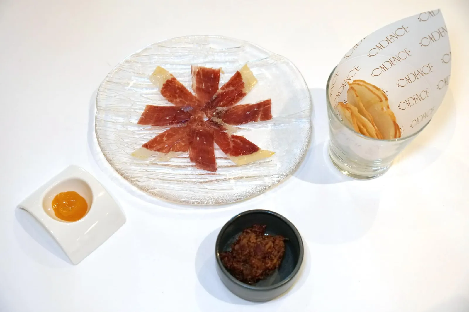 AMUSE BOUCHE jamón ibérico | homemade baguette | bacon marmalade ก่อนเข้าสู่คอร์ส Tasting Menu พนักงานจะนำเสิร์ฟ “แฮมหมูดำอิเบอริโก้” นำเข้าจากคาบสมุทรไอบีเรียแห่งประเทศสเปน ข้างกันคือ Homemade baguette, olive oil jam และ Bacon marmalade (14/20)