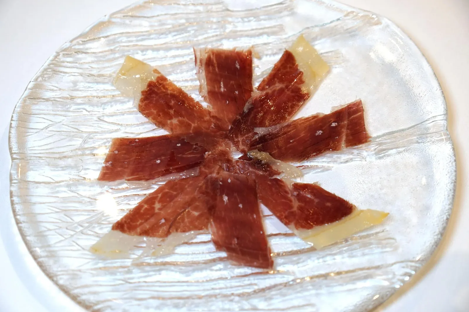 AMUSE BOUCHE jamón ibérico | homemade baguette | bacon marmalade Jamón ibérico ที่เสิร์ฟนี้ผ่านการหมักมานานถึง 48 เดือนจนมีรสชาติเค็มอุมามิ เนื้อสัมผัสหนึบ สู้ฟัน และมีกลิ่นคล้ายถั่วอันเป็นเอกลักษณ์ (14/20)